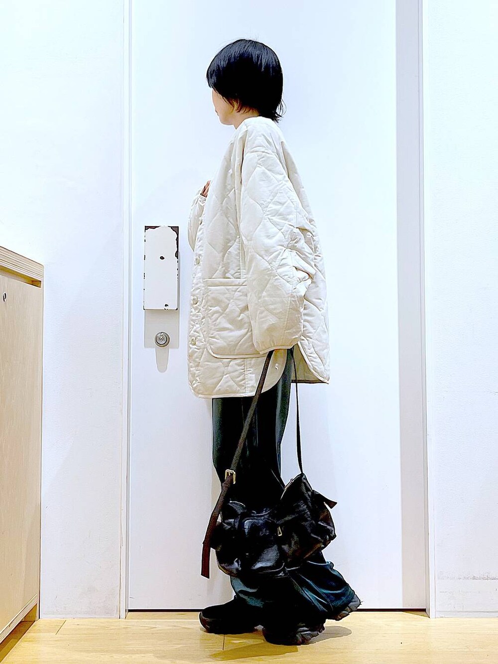 ベージュ系のブルゾン、ブラック系のTシャツ/カットソー、ブラック系のブーツを着用したレディースの冬コーディネートの3枚目の写真