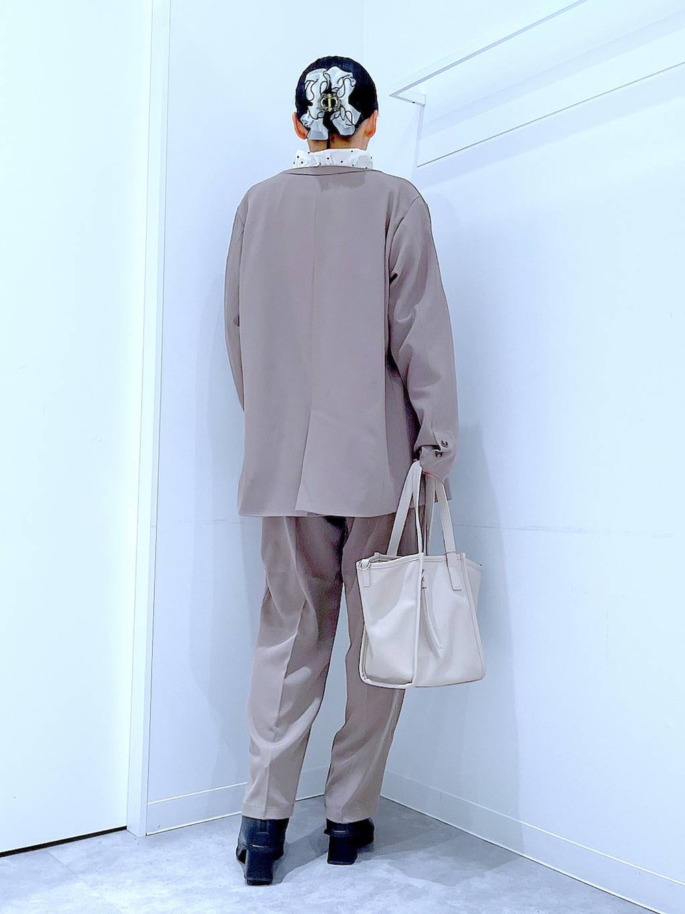 ブラック系のブーツ、グレー系のトートバッグ、ブラウン系のノーカラージャケットを着用したレディースの冬コーディネートの5枚目の写真