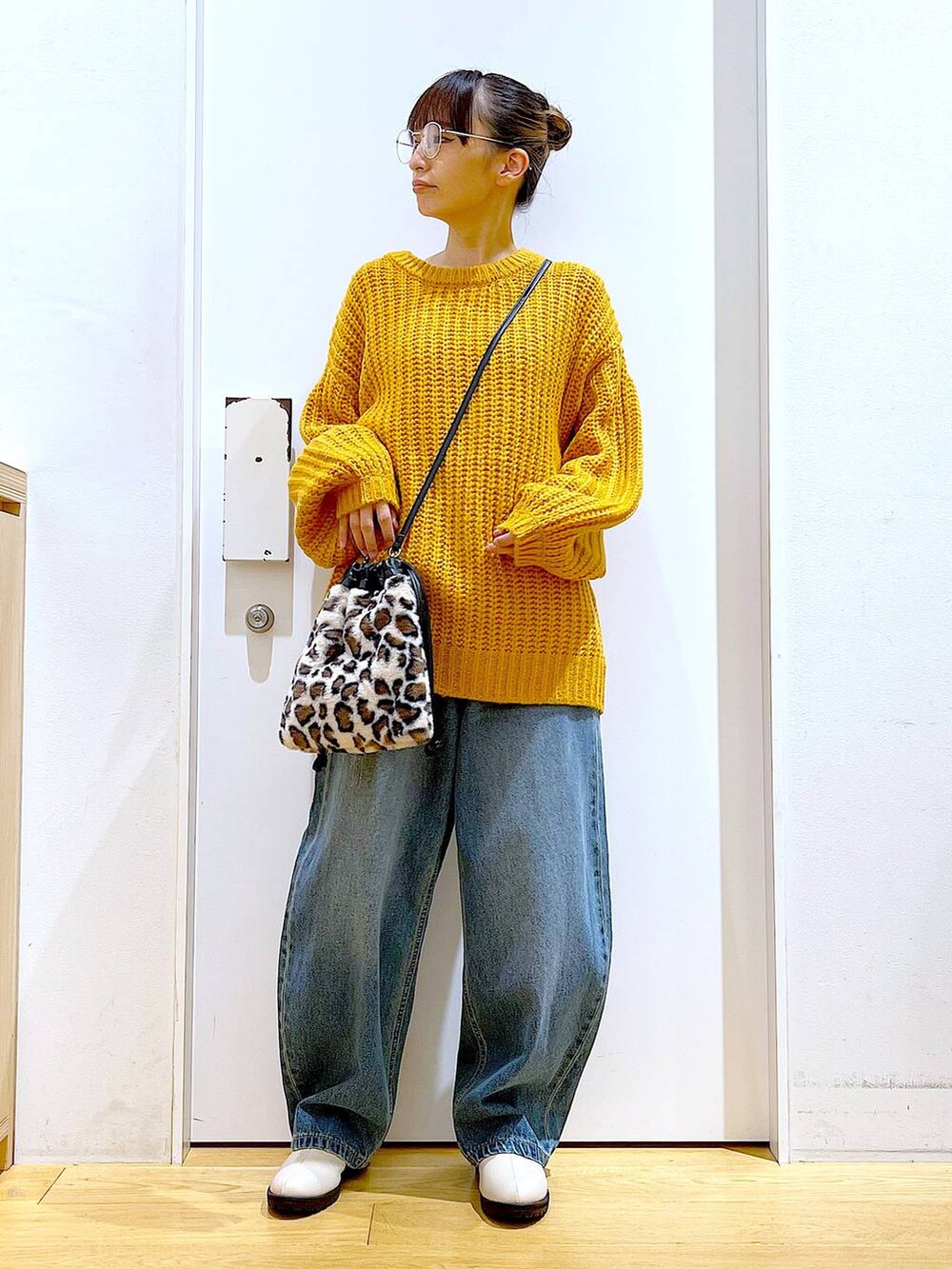 ベージュ系のブーツ、その他のショルダーバッグ、ブルー系のデニムパンツを着用したレディースの冬コーディネートの2枚目の写真