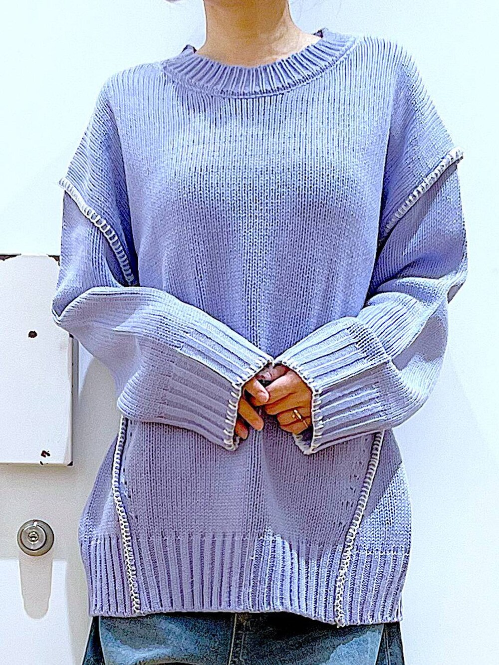 シルバー系のショルダーバッグ、ベージュ系のブーツ、ブルー系のデニムパンツを着用したレディースの冬コーディネートの7枚目の写真