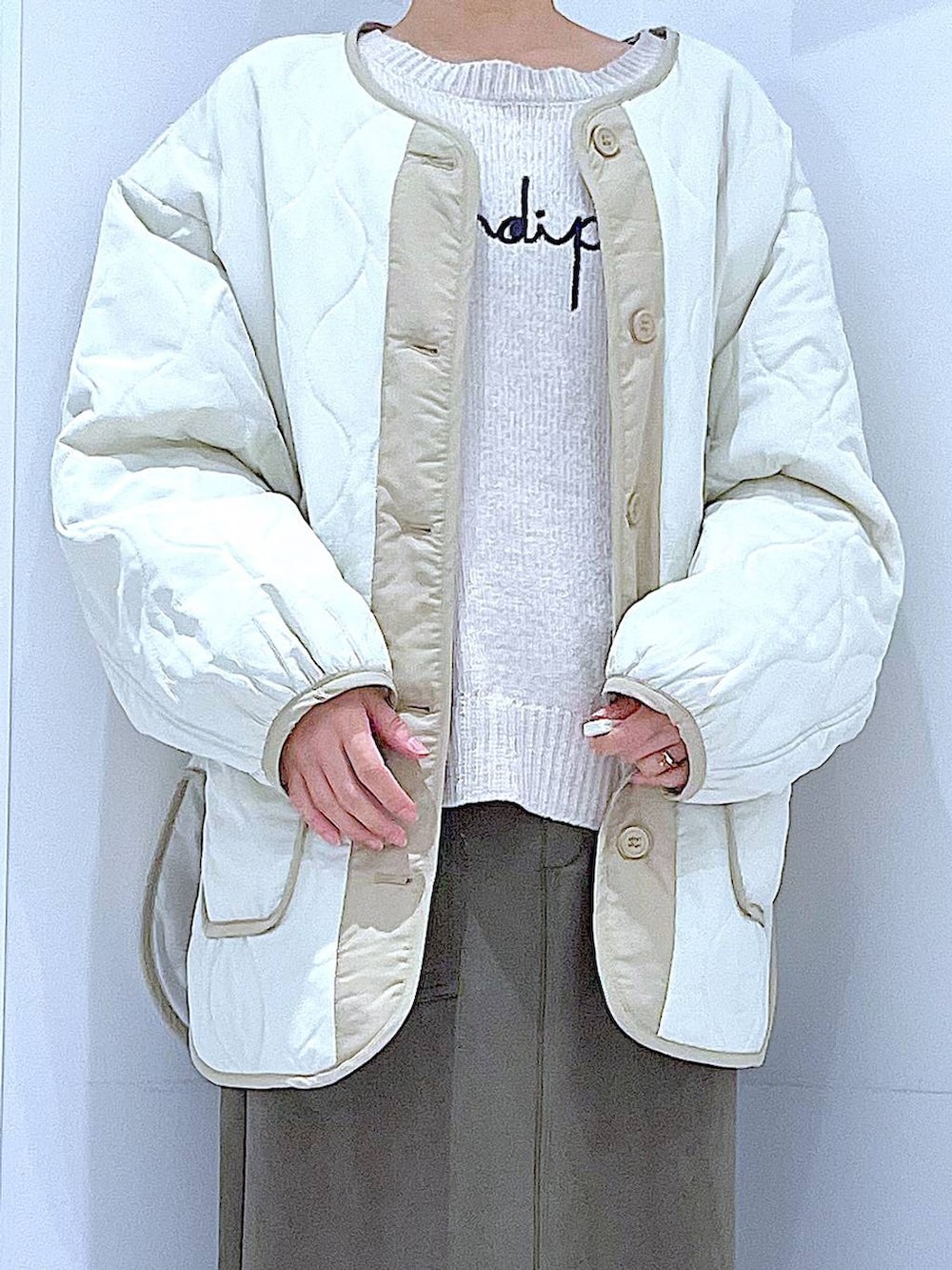 ベージュ系のブルゾン、ブラック系のブーツ、ベージュ系のニット/セーターを着用したレディースの冬コーディネートの7枚目の写真