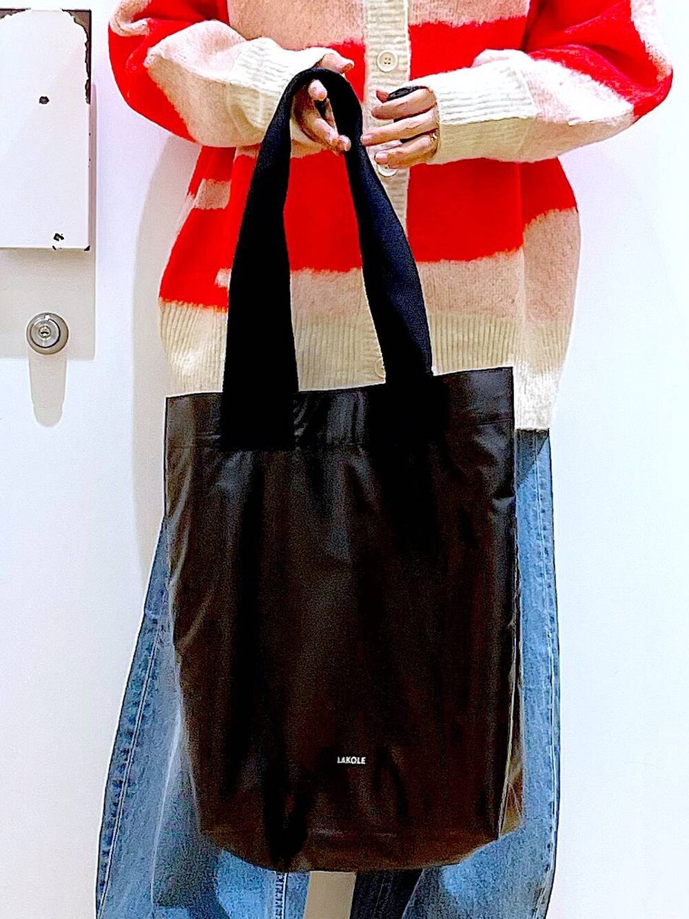 ベージュ系のブーツ、ベージュ系のニット/セーター、ブルー系のデニムパンツを着用したレディースの冬コーディネートの9枚目の写真