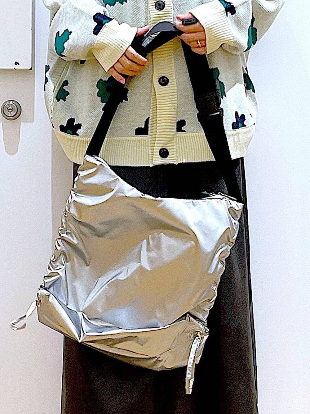 ベージュ系のカーディガン/ボレロ、ブラック系のブーツ、ブラック系のニット/セーターを着用したレディースの冬コーディネートの9枚目の写真