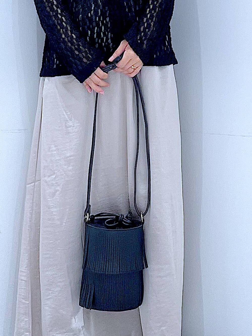 ブラック系のローファー、ブラック系のショルダーバッグ、ベージュ系のスカートを着用したレディースの秋コーディネートの9枚目の写真