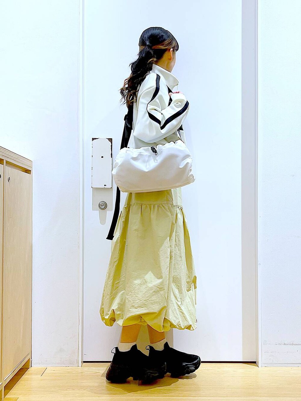 ベージュ系のブルゾン、ベージュ系のスカート、ホワイト系のショルダーバッグを着用したレディースの冬コーディネートの4枚目の写真