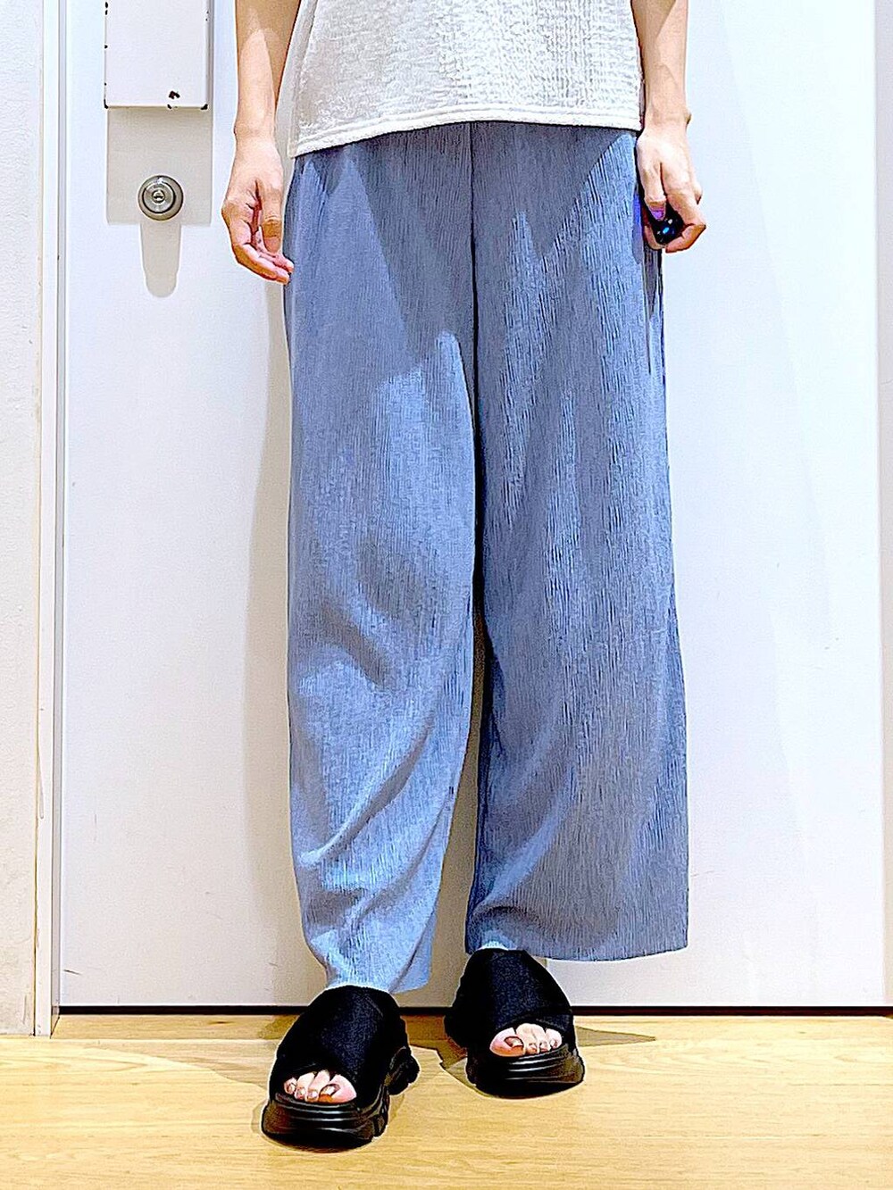 ブラック系のトートバッグ、ブラック系のサンダル、ホワイト系のTシャツ/カットソーを着用したレディースの夏コーディネートの8枚目の写真