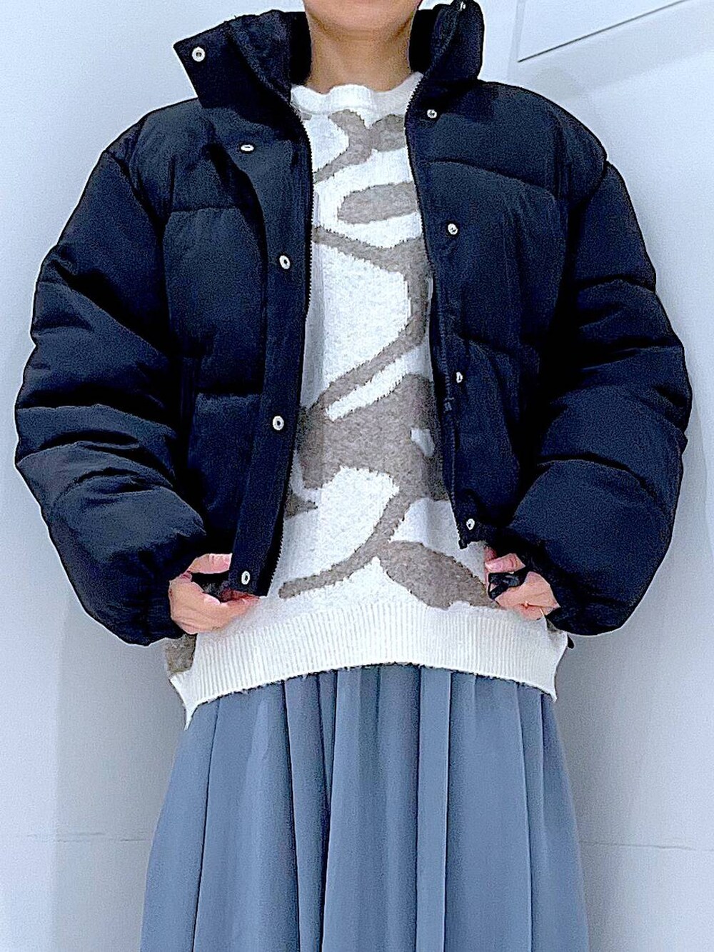 ブラック系のブルゾン、ブラック系のブーツ、ベージュ系のニット/セーターを着用したレディースの冬コーディネートの7枚目の写真