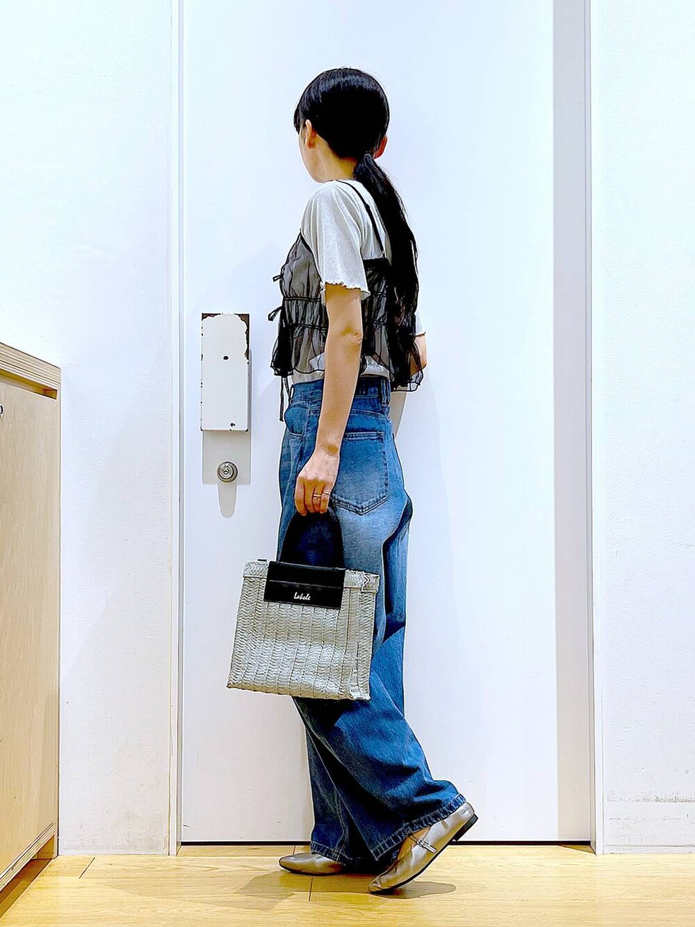 ブルー系のデニムパンツ、その他のパンプス、グレー系のショルダーバッグを着用したレディースの夏コーディネートの3枚目の写真