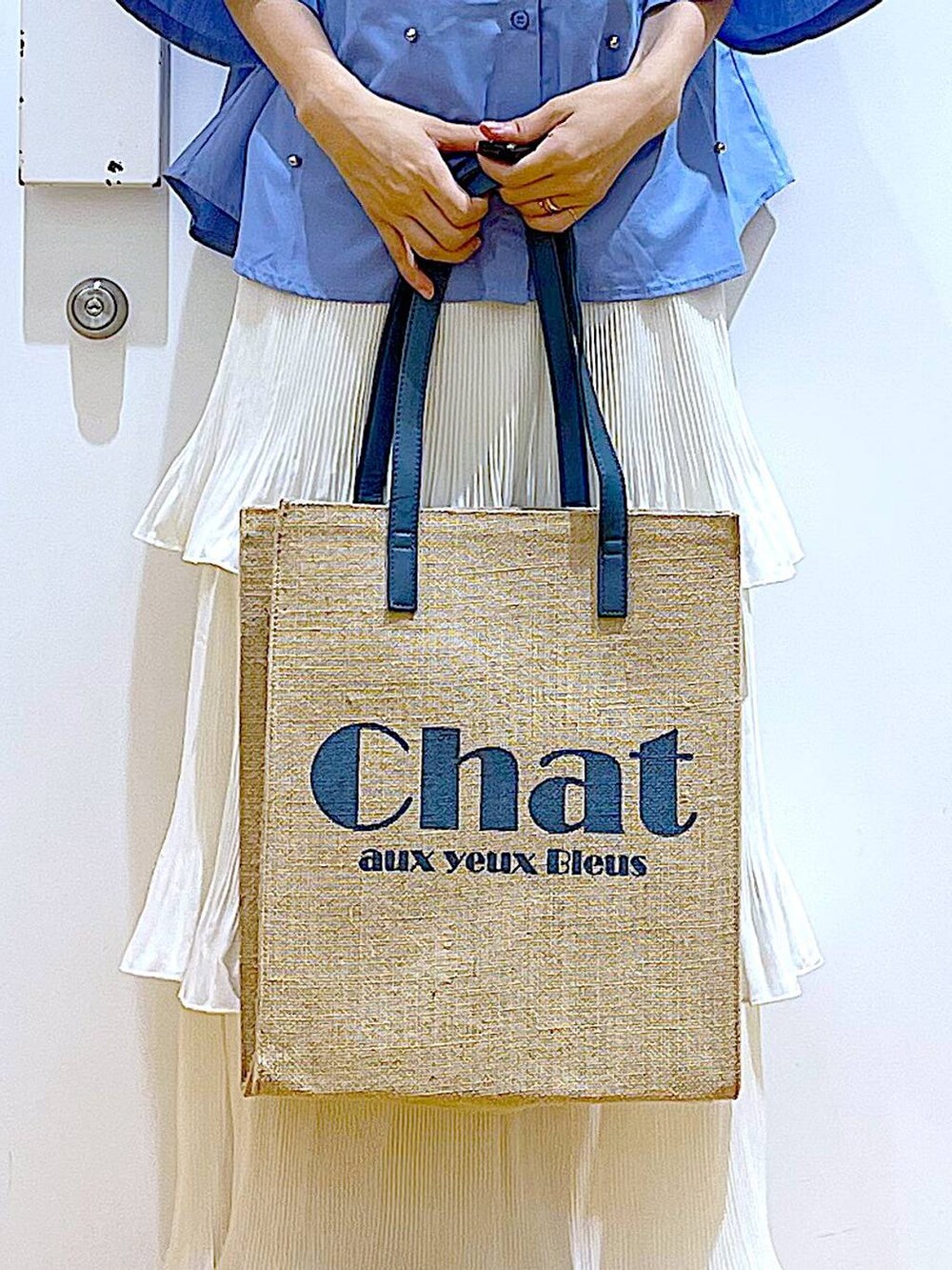 ベージュ系のスカート、ブルー系のトートバッグ、ホワイト系のサンダルを着用したレディースの夏コーディネートの9枚目の写真