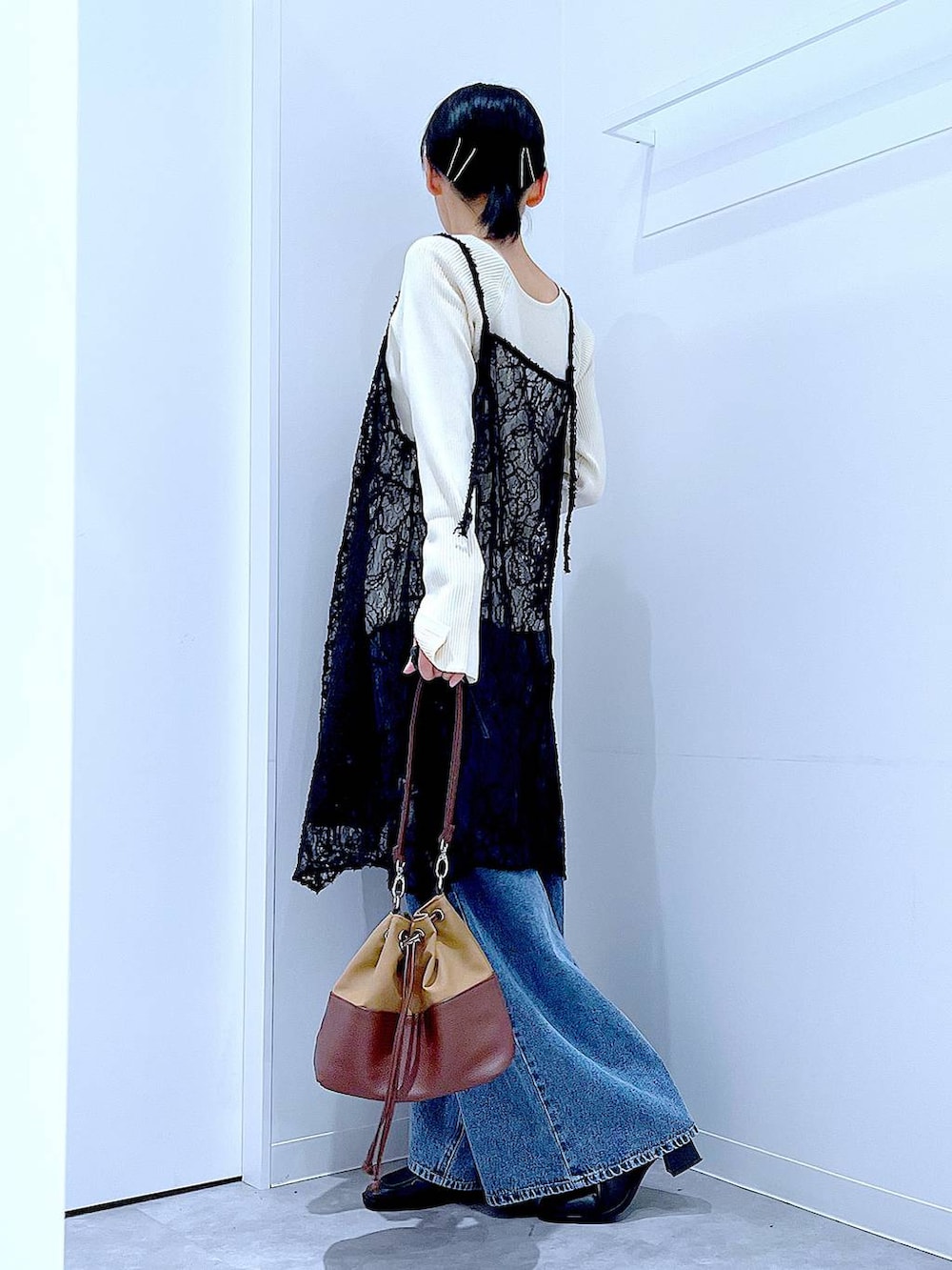 ベージュ系のニット/セーター、ブルー系のデニムパンツ、ベージュ系のショルダーバッグを着用したレディースの秋コーディネートの3枚目の写真