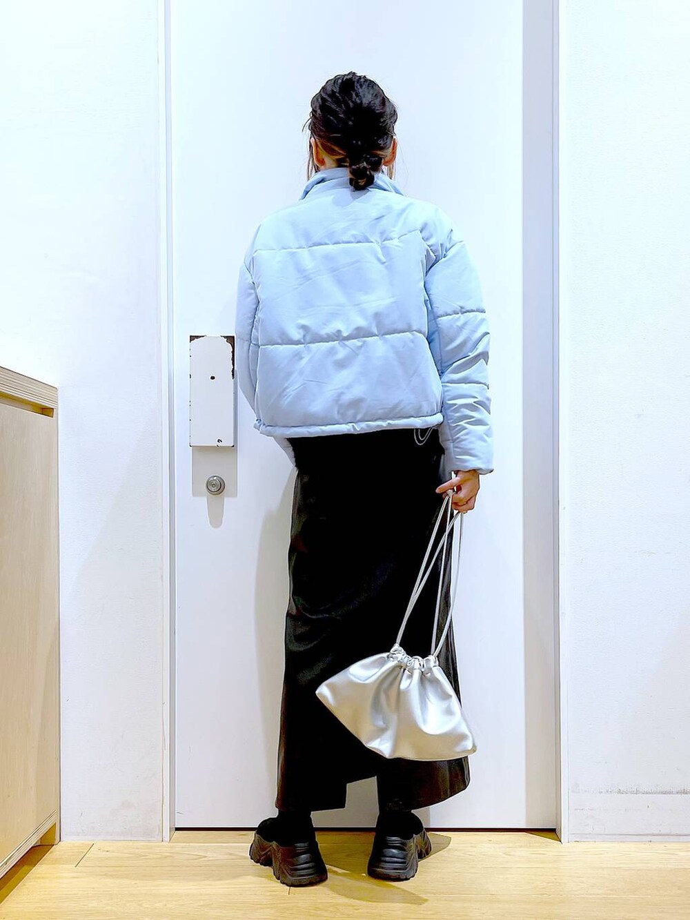 ブラック系のブーツ、シルバー系のショルダーバッグ、ブルー系のナイロンジャケットを着用したレディースの冬コーディネートの5枚目の写真