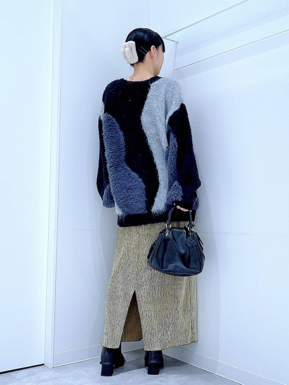 グレー系のニット/セーター、ブラック系のブーツ、ブラック系のショルダーバッグを着用したレディースの冬コーディネートの5枚目の写真