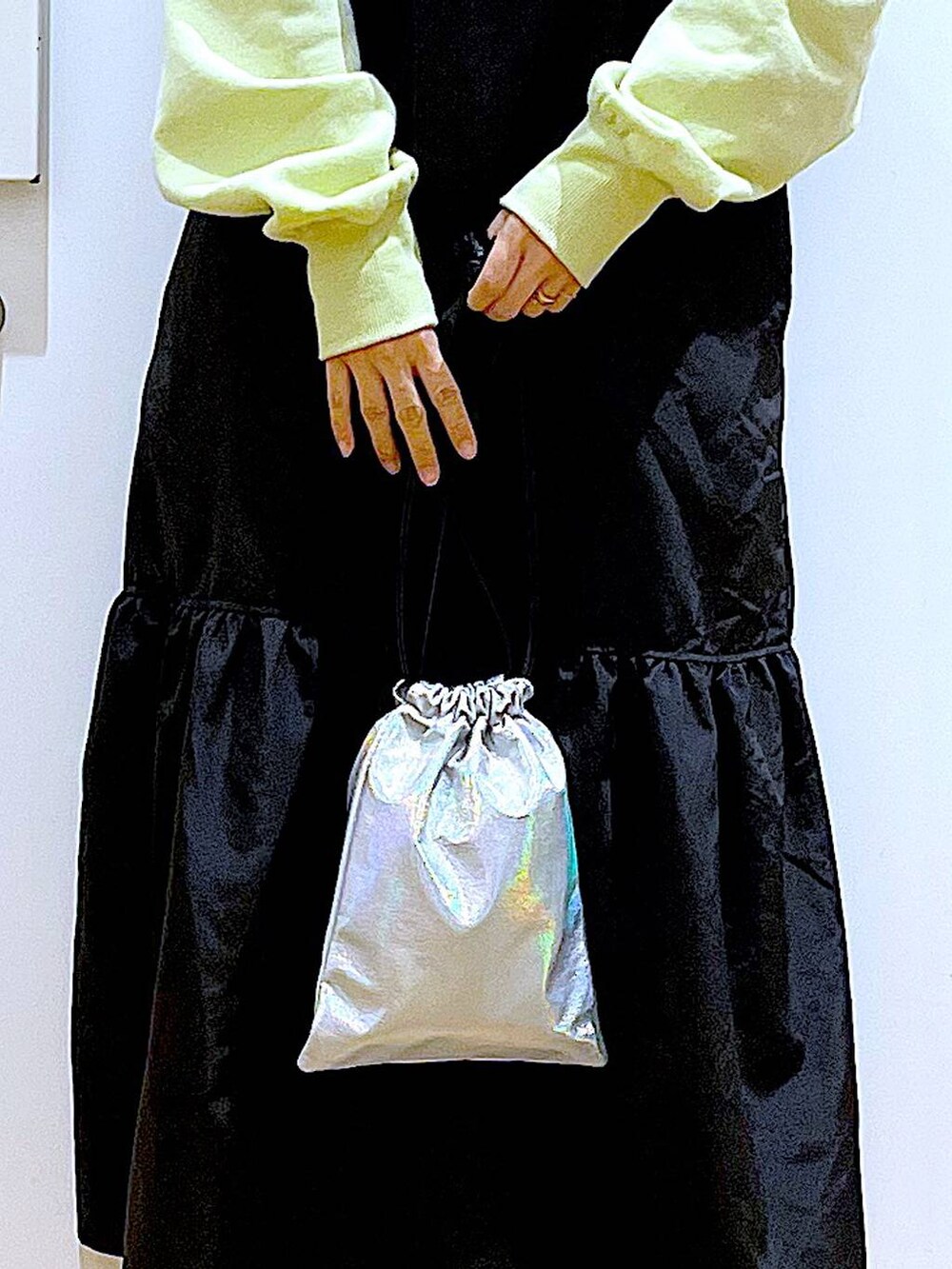 イエロー系のスウェット、ベージュ系のブーツ、その他のショルダーバッグを着用したレディースの冬コーディネートの9枚目の写真