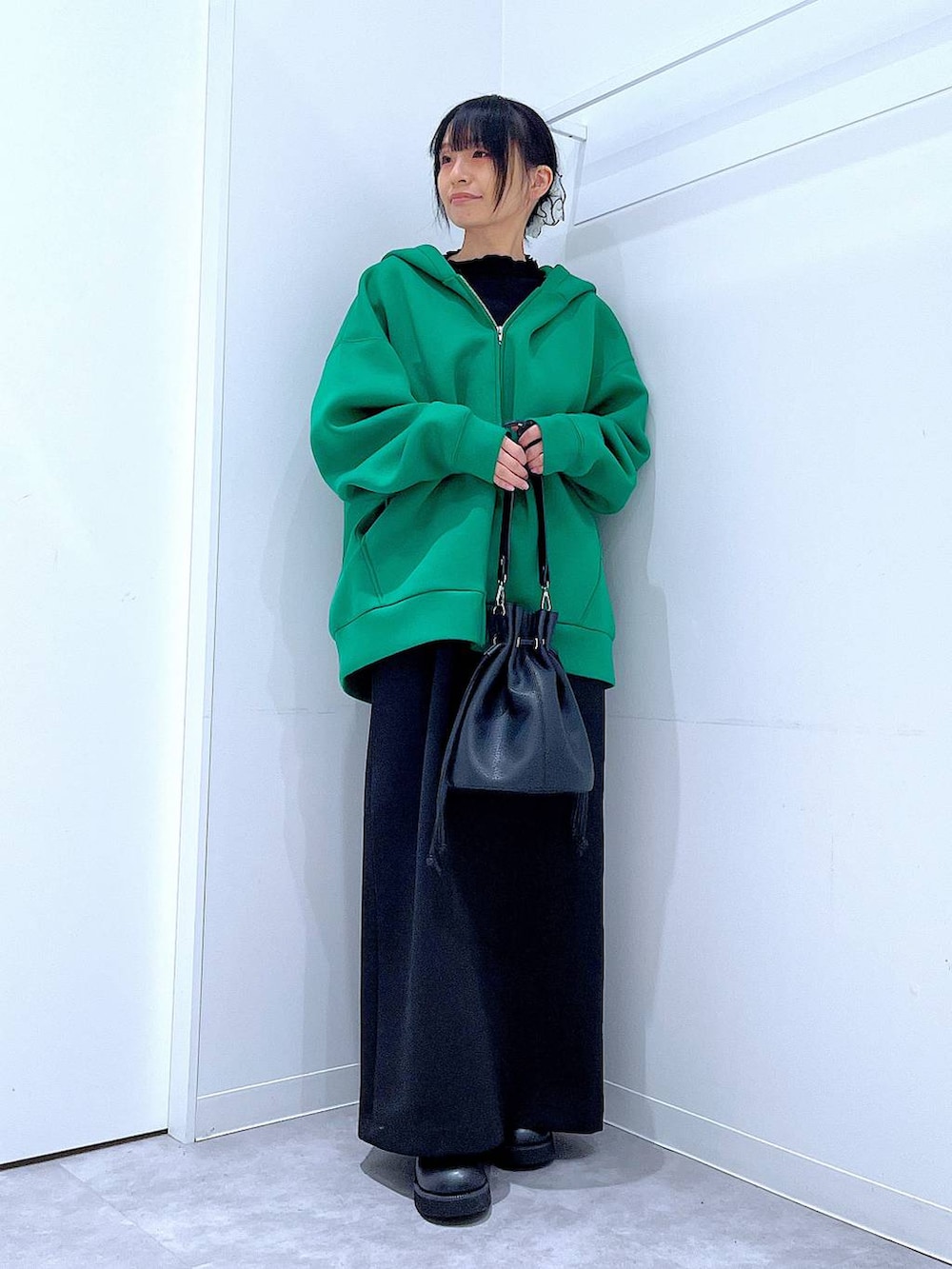 ブラック系のスカート、ブラック系のサンダル、ブラック系のショルダーバッグを着用したレディースの冬コーディネートの2枚目の写真