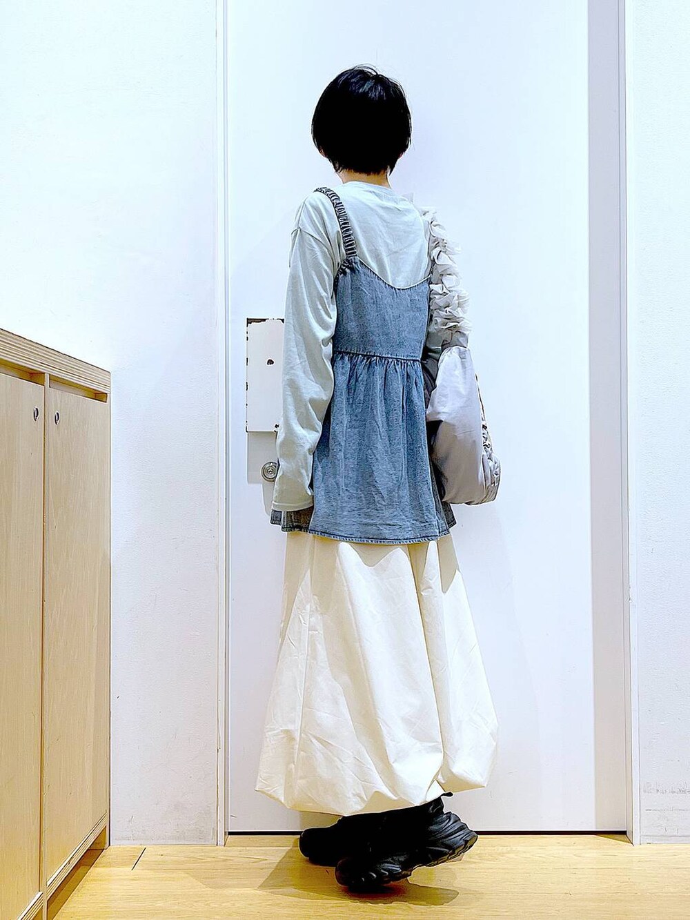 グレー系のショルダーバッグ、ブラック系のスニーカー、ブルー系のその他トップスを着用したレディースの春コーディネートの3枚目の写真