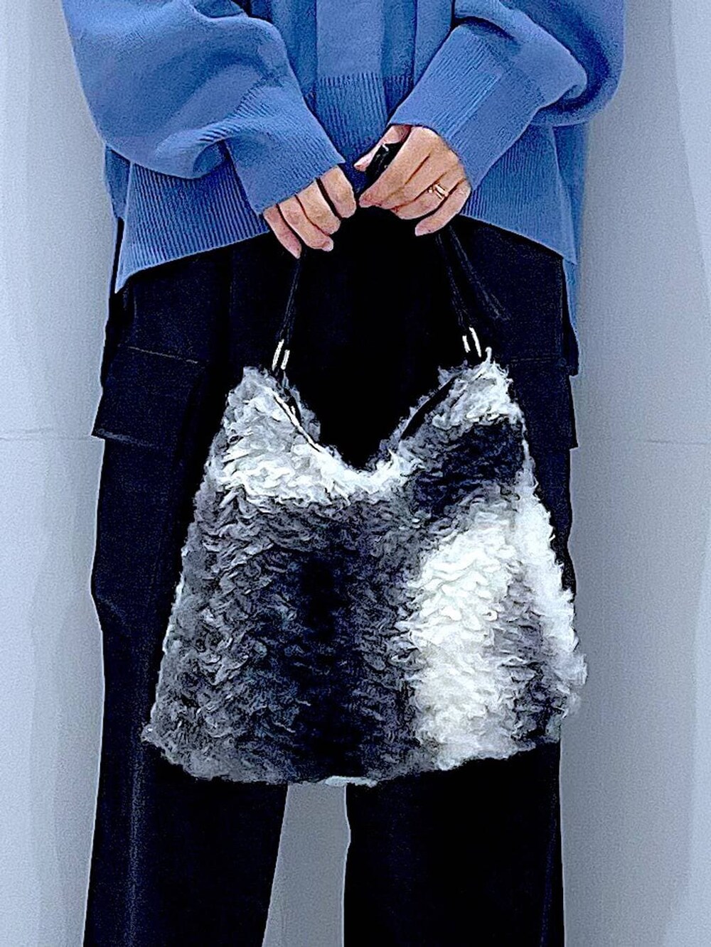 ブルー系のニット/セーター、ブラック系のブーツ、ブラック系のショルダーバッグを着用したレディースの冬コーディネートの9枚目の写真