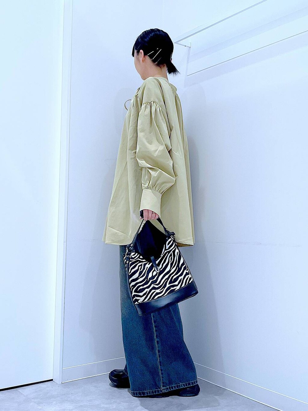 ブラック系のローファー、その他のショルダーバッグ、ブルー系のデニムパンツを着用したレディースの秋コーディネートの3枚目の写真