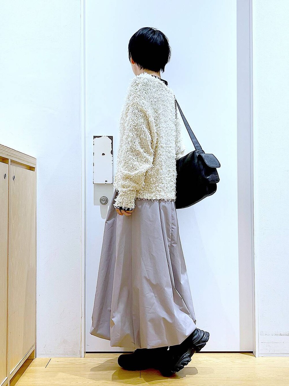 ブラック系のスニーカー、ブラック系のTシャツ/カットソー、グレー系のスカートを着用したレディースの春コーディネートの3枚目の写真