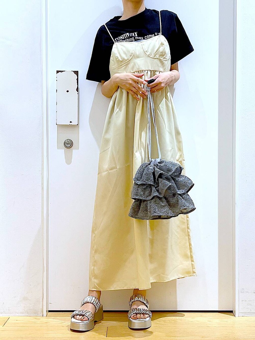 シルバー系のショルダーバッグ、シルバー系のサンダル、ブラック系のTシャツ/カットソーを着用したレディースの夏コーディネートの3枚目の写真