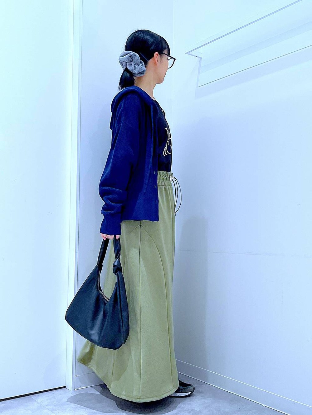 ブラック系のTシャツ/カットソー、ブラック系のショルダーバッグ、グリーン系のスカートを着用したレディースの春コーディネートの4枚目の写真