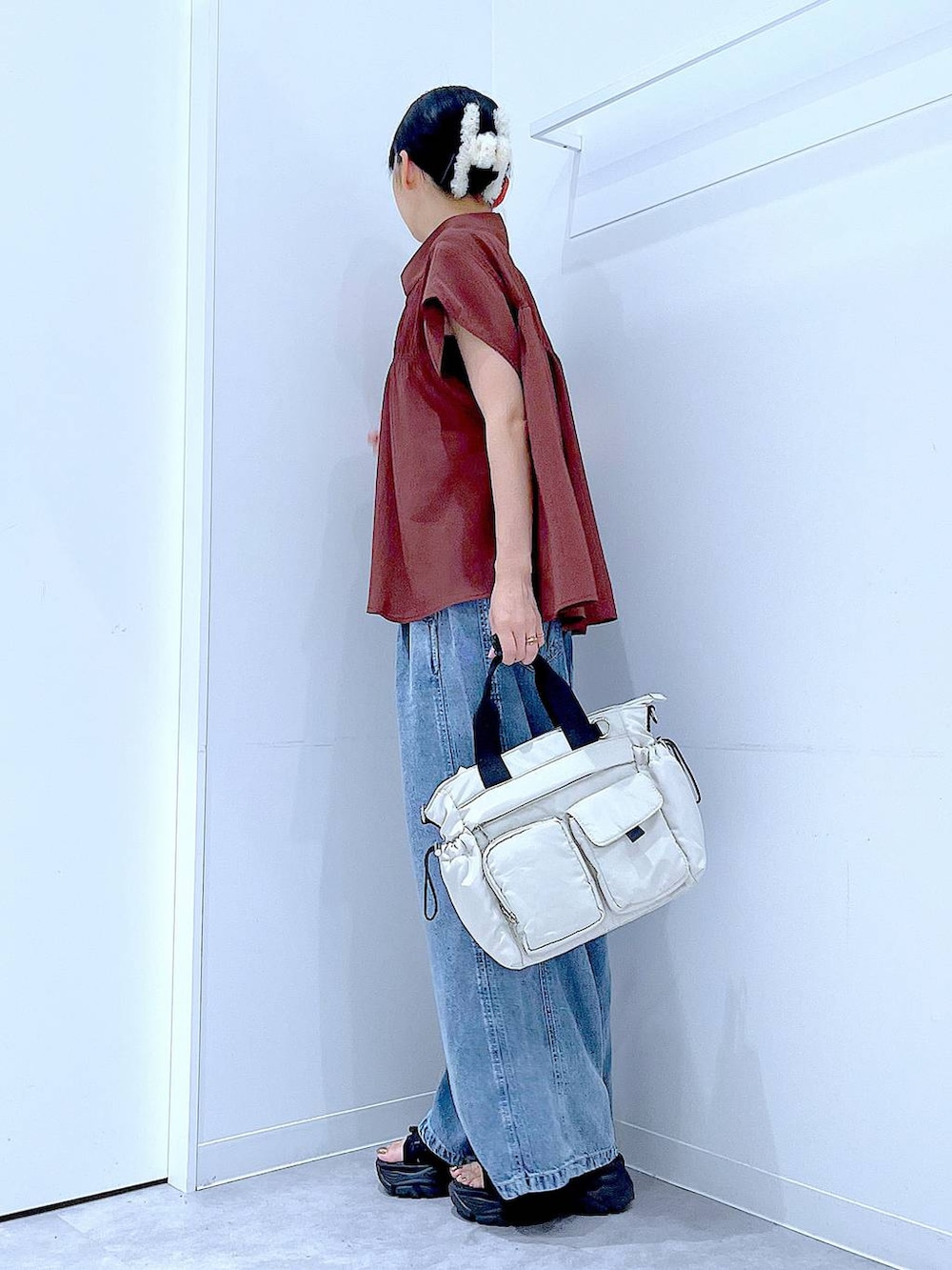 ホワイト系のトートバッグ、ブルー系のデニムパンツ、ブラウン系のシャツ/ブラウスを着用したレディースの夏コーディネートの3枚目の写真