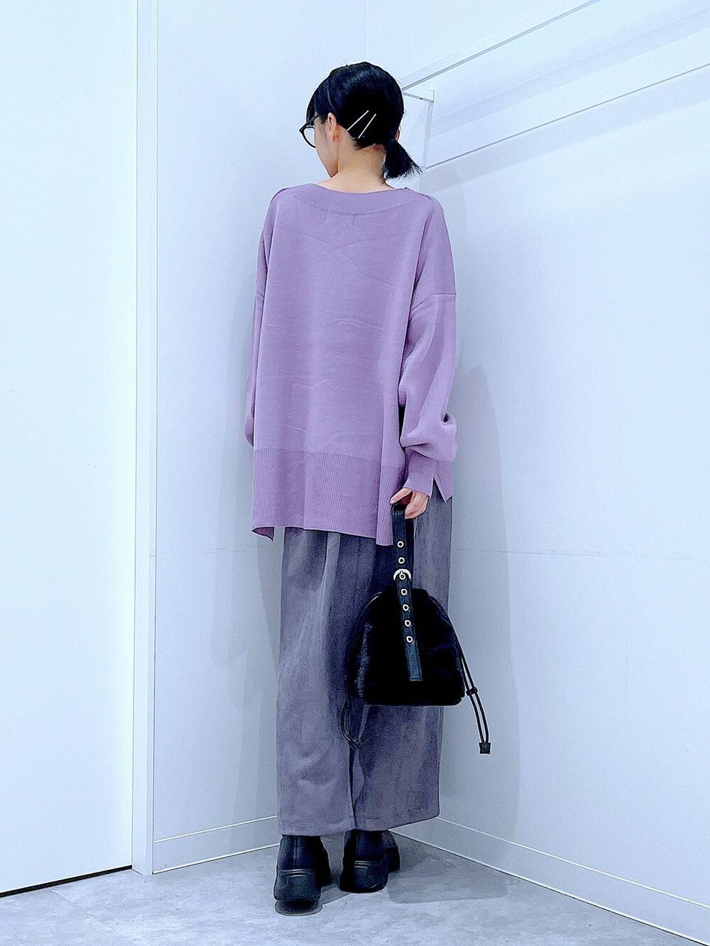 ブラック系のハンドバッグ、ブラック系のブーツ、グレー系のスカートを着用したレディースの冬コーディネートの5枚目の写真