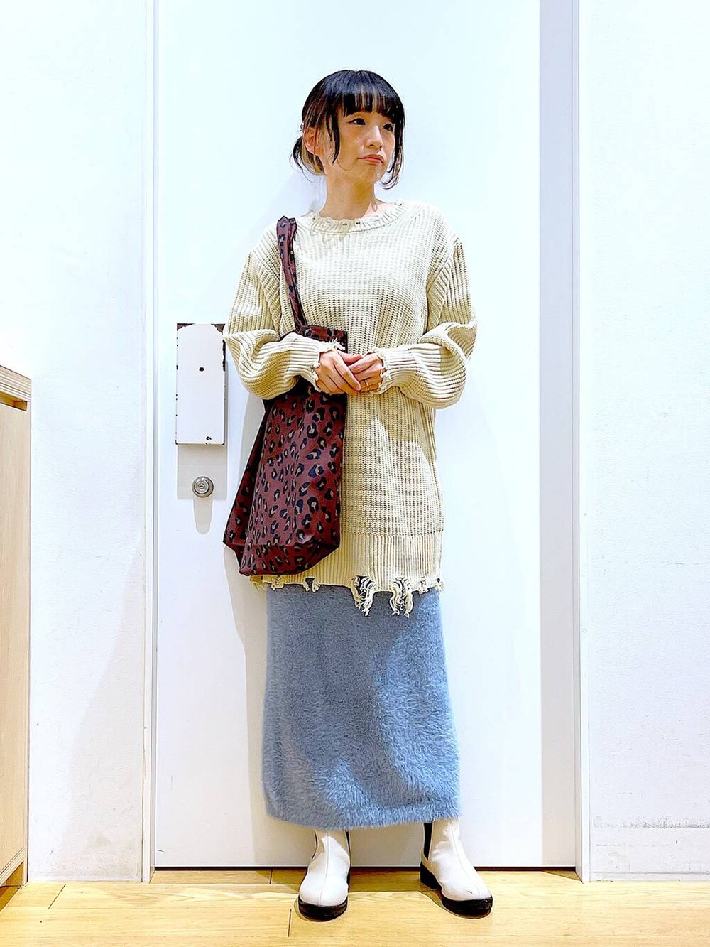 ベージュ系のブーツ、その他のトートバッグ、ブルー系のスカートを着用したレディースの冬コーディネートの2枚目の写真