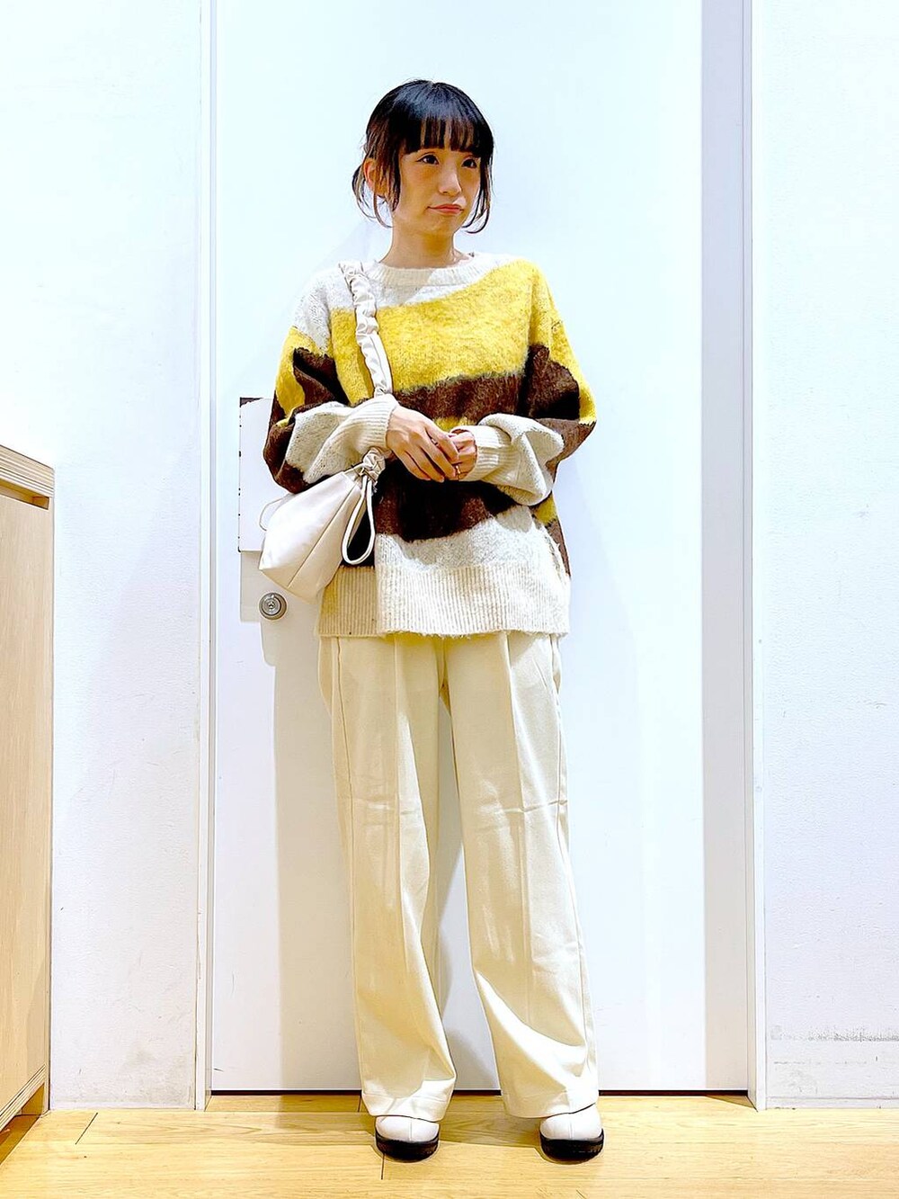 ホワイト系のショルダーバッグ、ベージュ系のブーツ、ベージュ系のその他パンツを着用したレディースの冬コーディネートの2枚目の写真