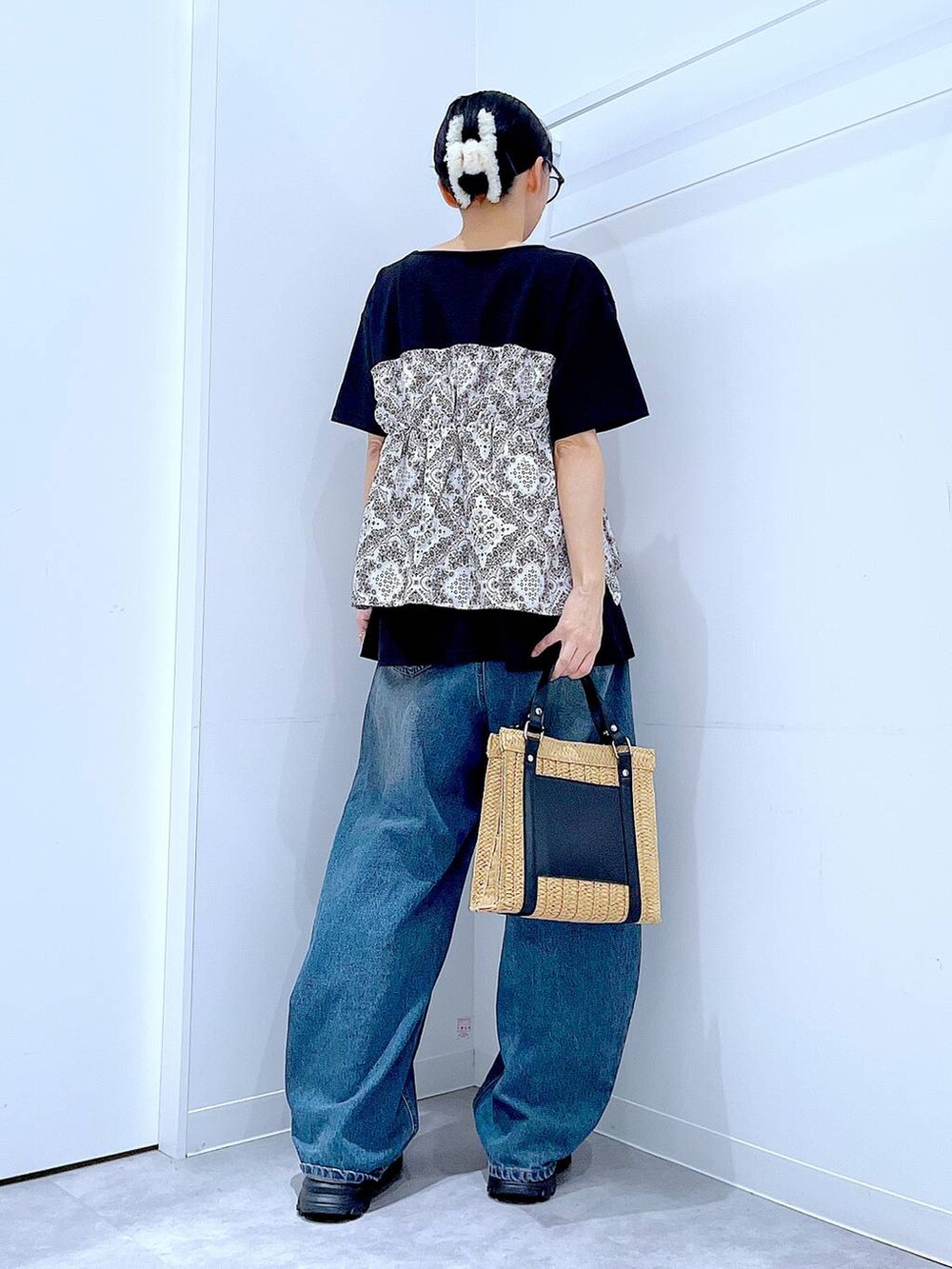ブルー系のデニムパンツ、ブラック系のスニーカー、ブラック系のTシャツ/カットソーを着用したレディースの春コーディネートの5枚目の写真