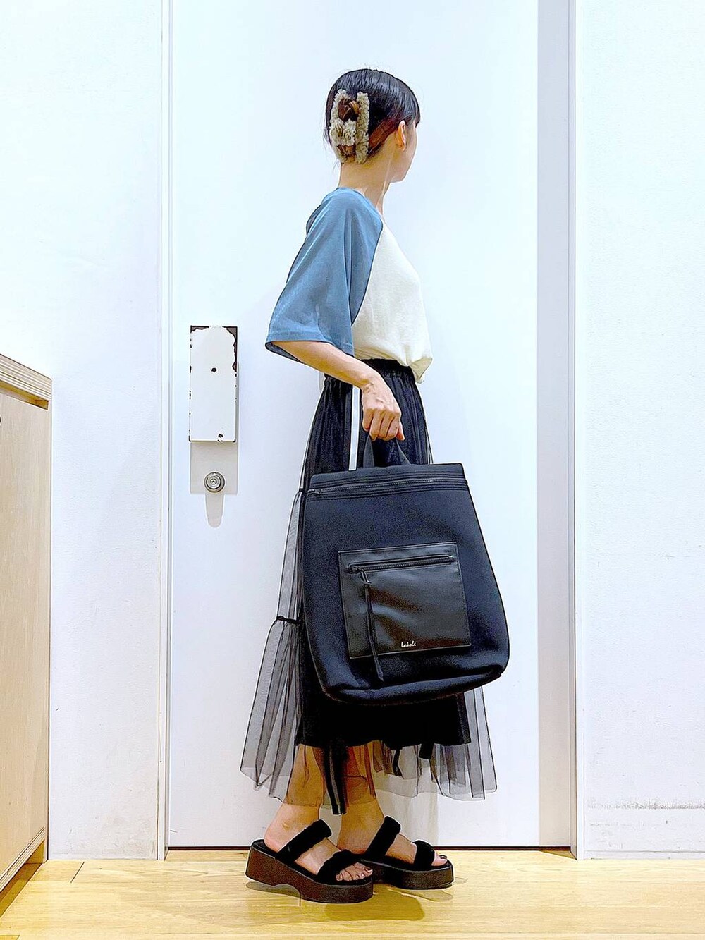 ブラック系のサンダル、ブルー系のTシャツ/カットソー、ブラック系のスカートを着用したレディースの夏コーディネートの4枚目の写真