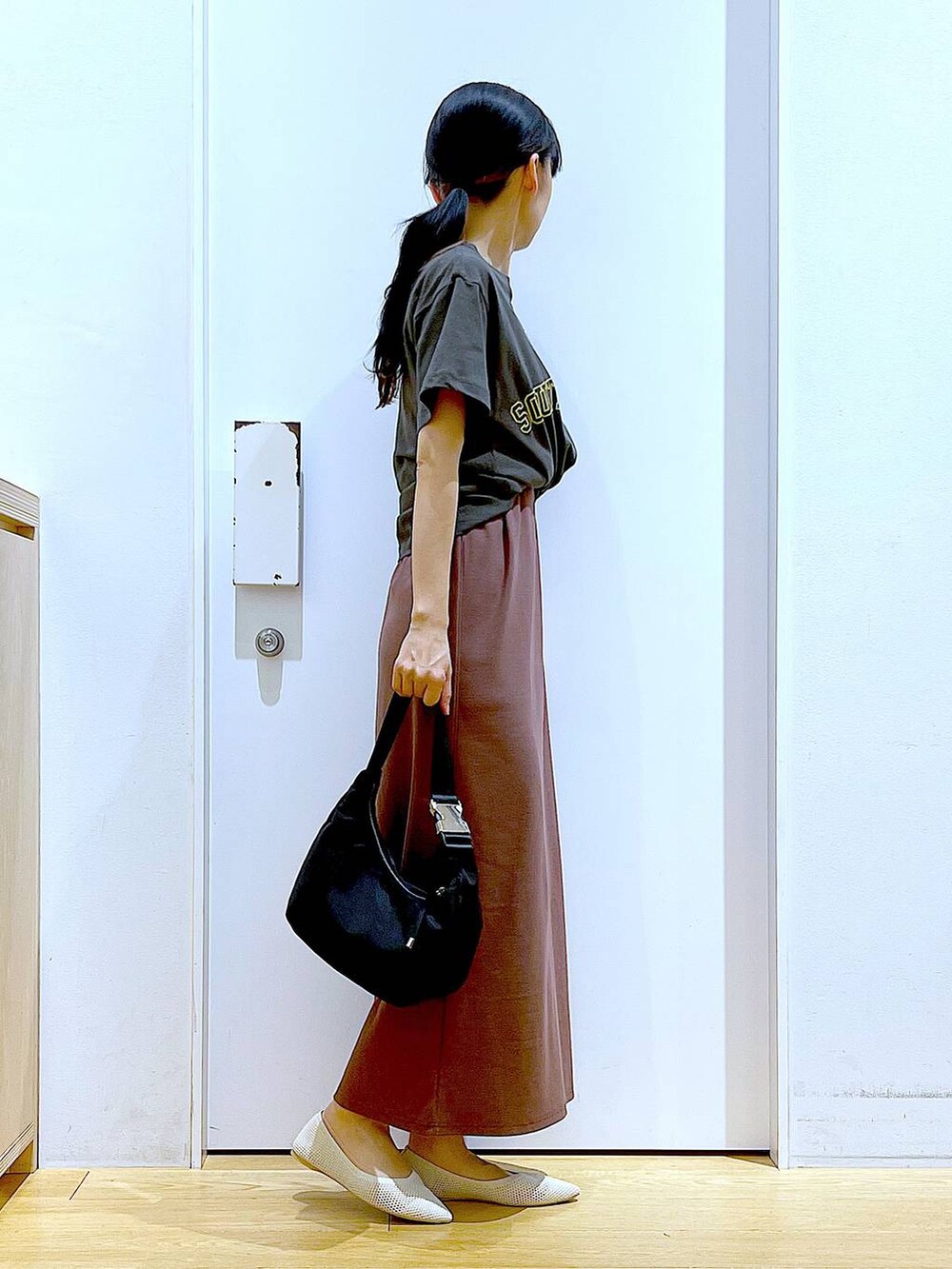 レッド系のワンピース、ブラック系のショルダーバッグ、ホワイト系のパンプスを着用したレディースの春コーディネートの4枚目の写真