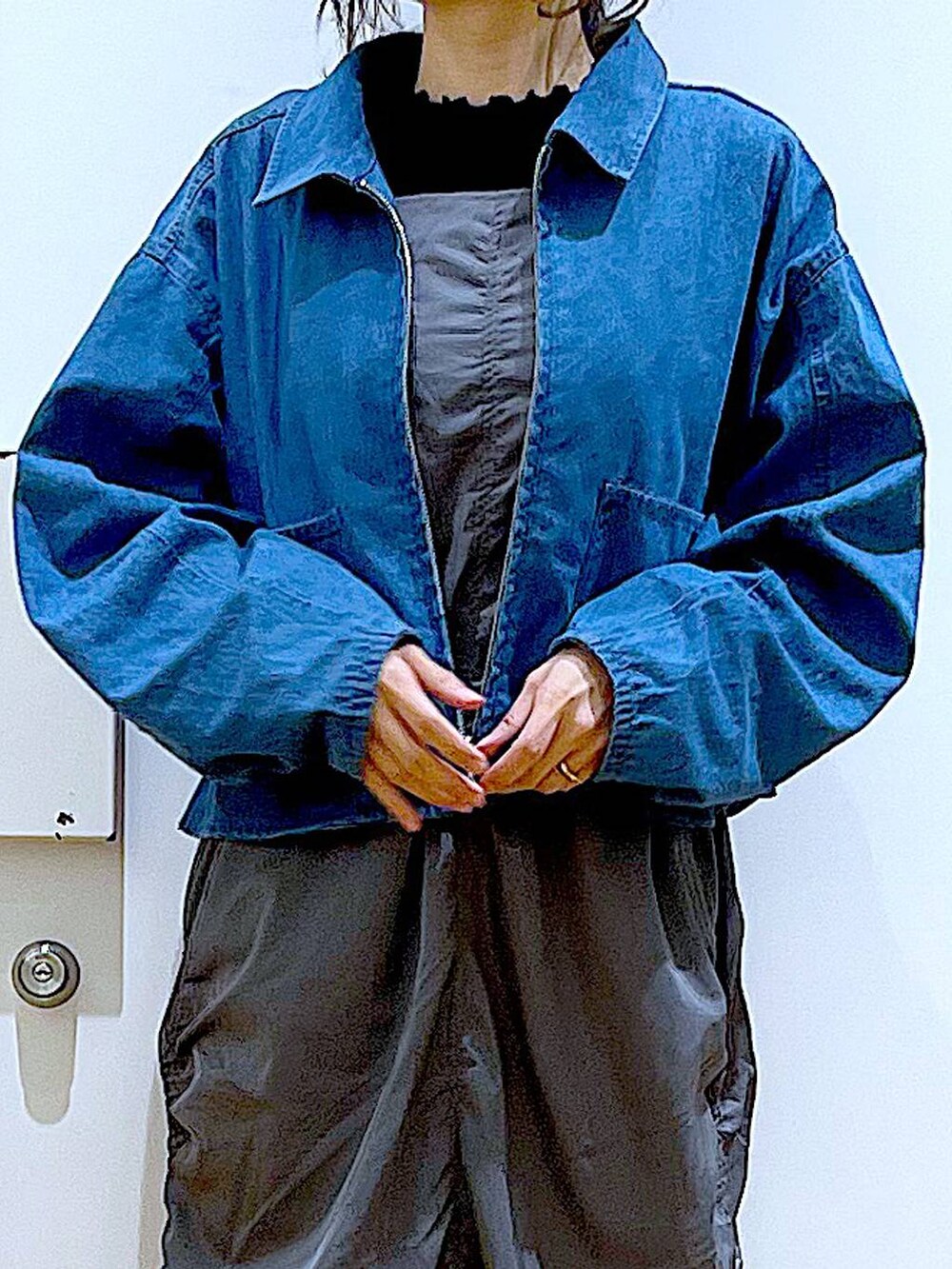 ブルー系のデニムジャケット、ホワイト系のショルダーバッグ、グレー系のワンピースを着用したレディースの春コーディネートの7枚目の写真