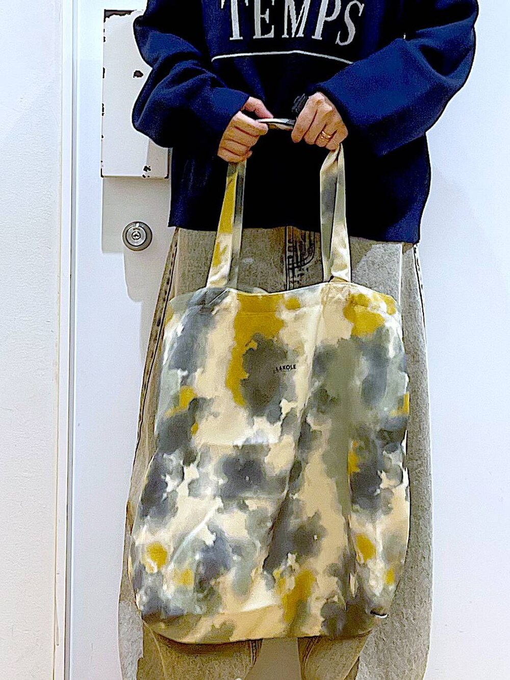 ブラック系のブーツ、ベージュ系のデニムパンツ、イエロー系のトートバッグを着用したレディースの冬コーディネートの9枚目の写真