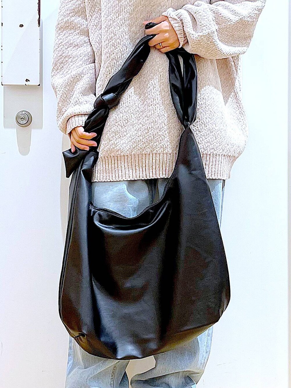 ホワイト系のニット/セーター、ブラック系のショルダーバッグ、ブラック系のブーツを着用したレディースの冬コーディネートの9枚目の写真