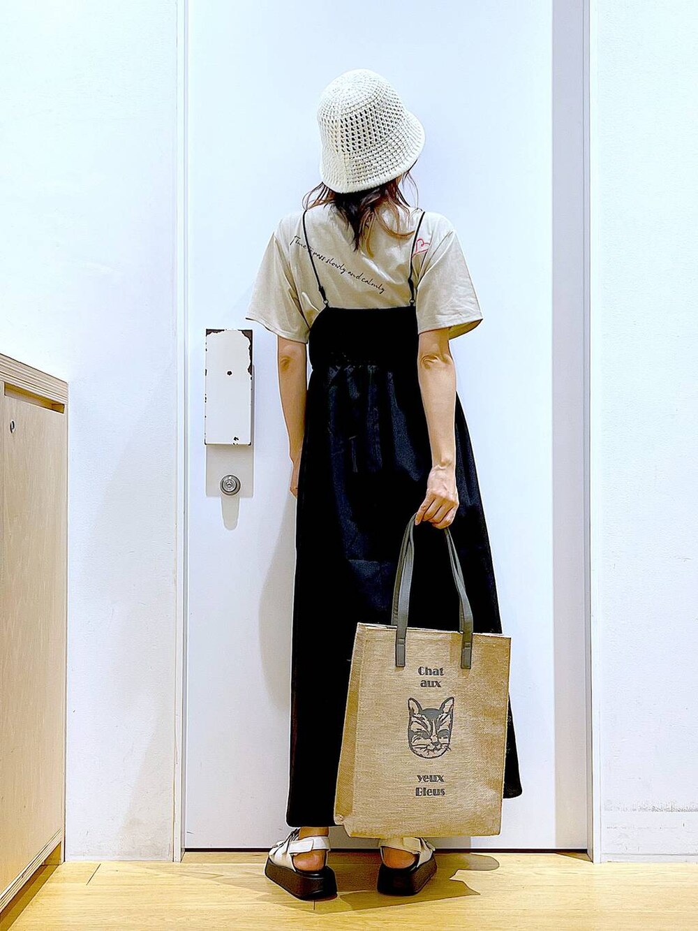 ホワイト系のサンダル、グレー系のトートバッグ、ブラック系のワンピースを着用したレディースの夏コーディネートの5枚目の写真