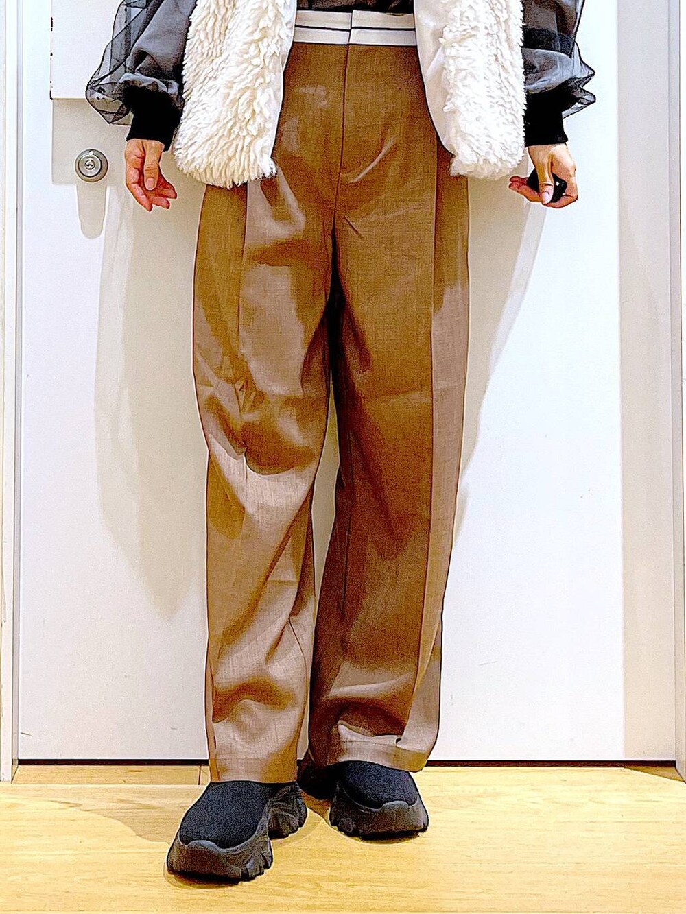 ベージュ系のベスト、ブラウン系のハンドバッグ、ブラック系のブーツを着用したレディースの冬コーディネートの8枚目の写真