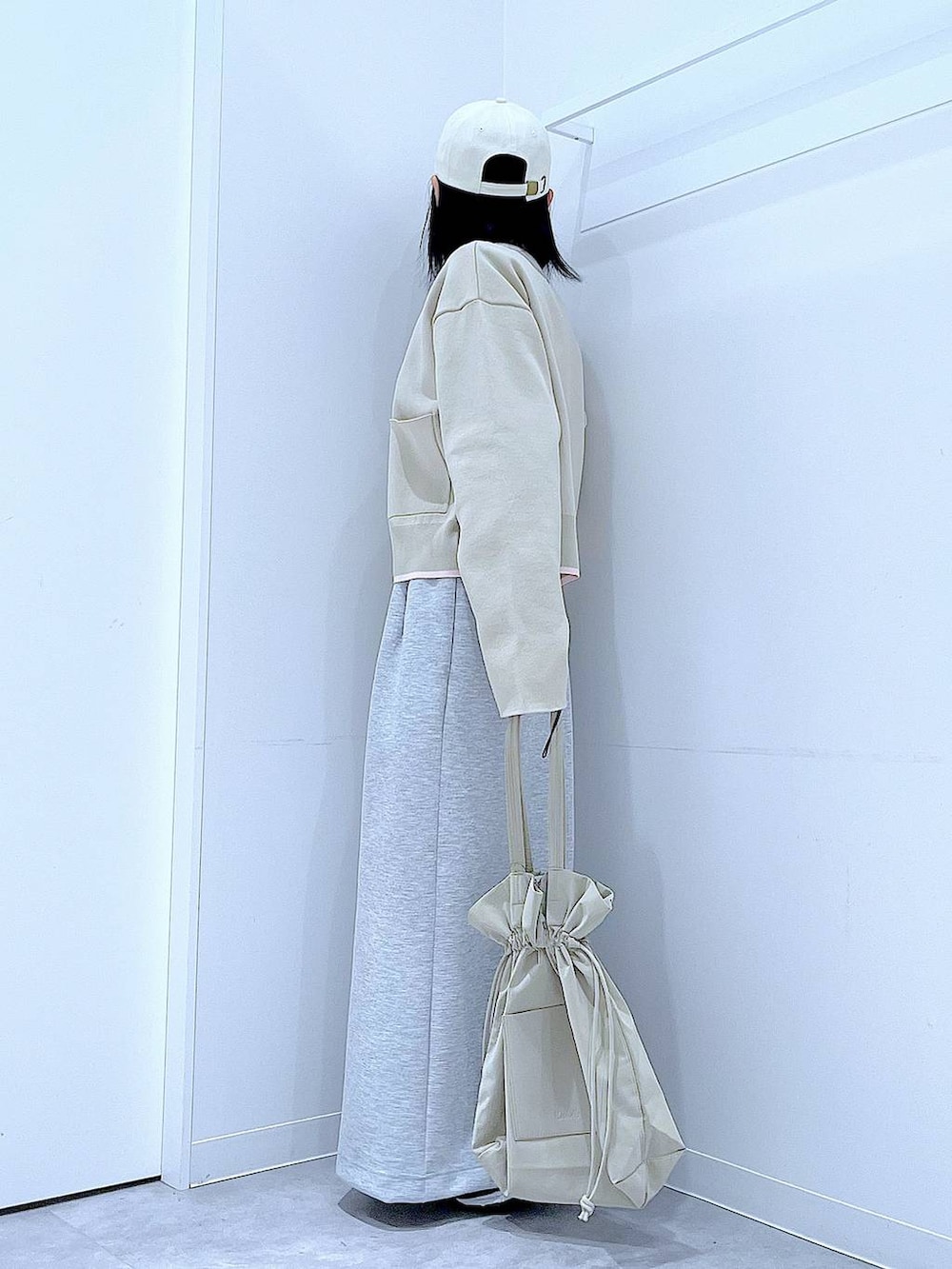 ブラック系のTシャツ/カットソー、ベージュ系のトートバッグ、グレー系のスカートを着用したレディースの冬コーディネートの3枚目の写真