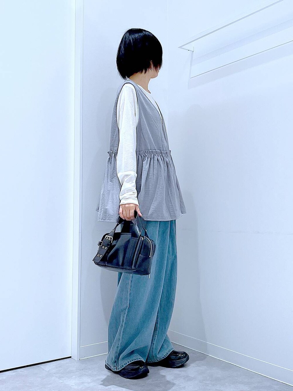 ホワイト系のTシャツ/カットソー、ブラック系のローファー、ブラック系のショルダーバッグを着用したレディースの秋コーディネートの4枚目の写真