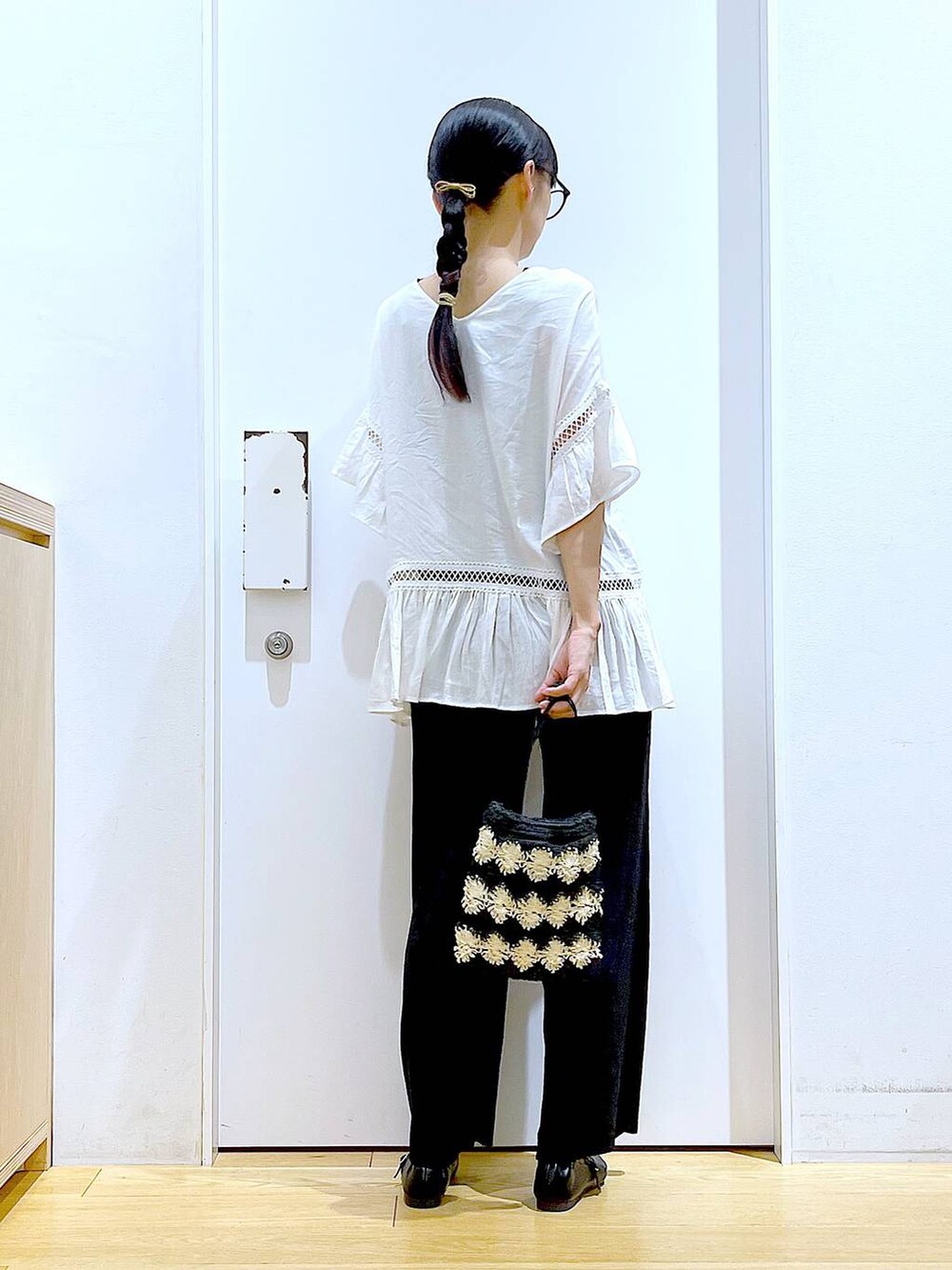 ホワイト系のチュニック、ブラック系のその他パンツ、ブラック系のパンプスを着用したレディースの夏コーディネートの5枚目の写真