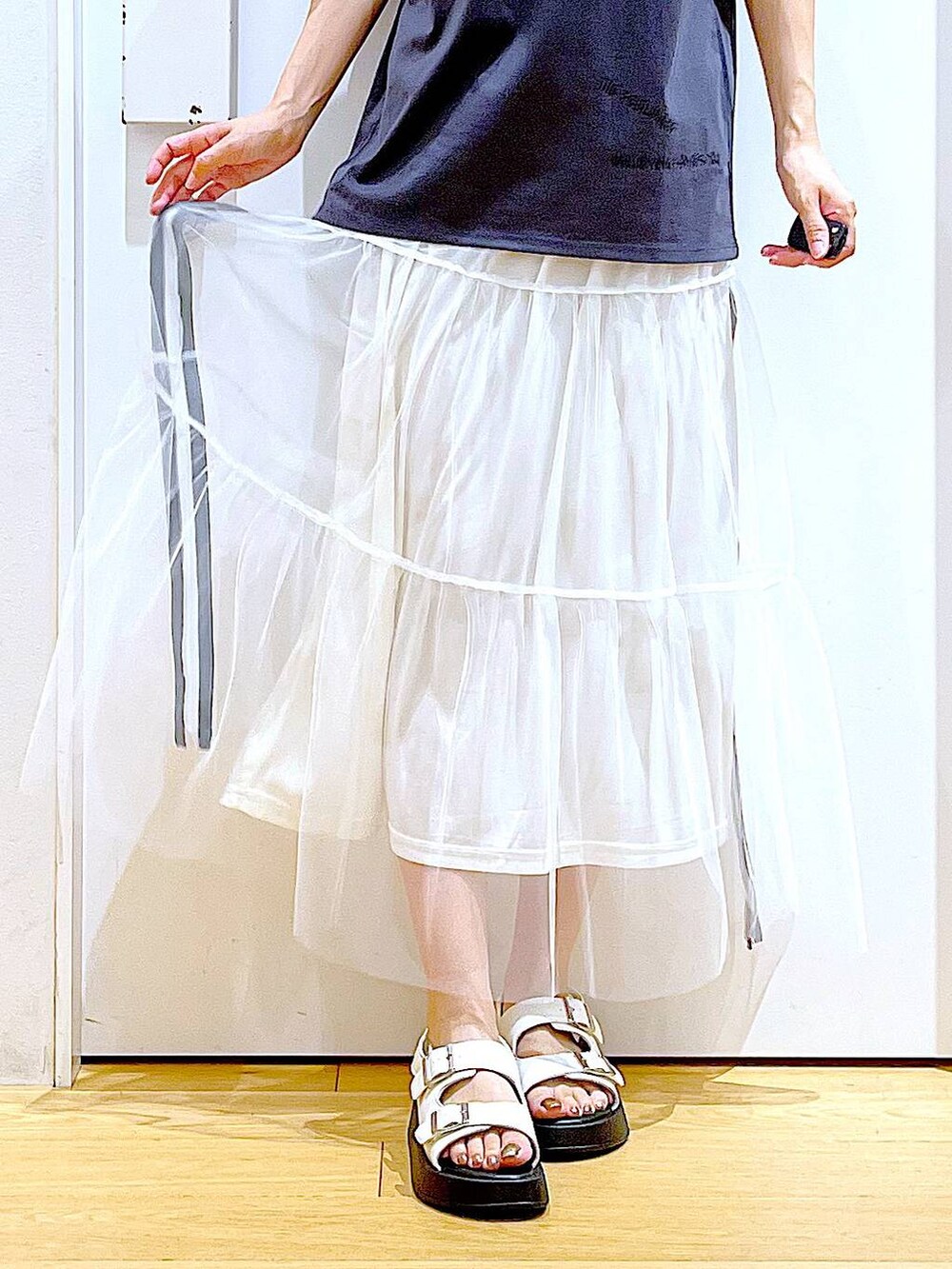 ホワイト系のサンダル、ホワイト系のショルダーバッグ、ホワイト系のスカートを着用したレディースの夏コーディネートの8枚目の写真