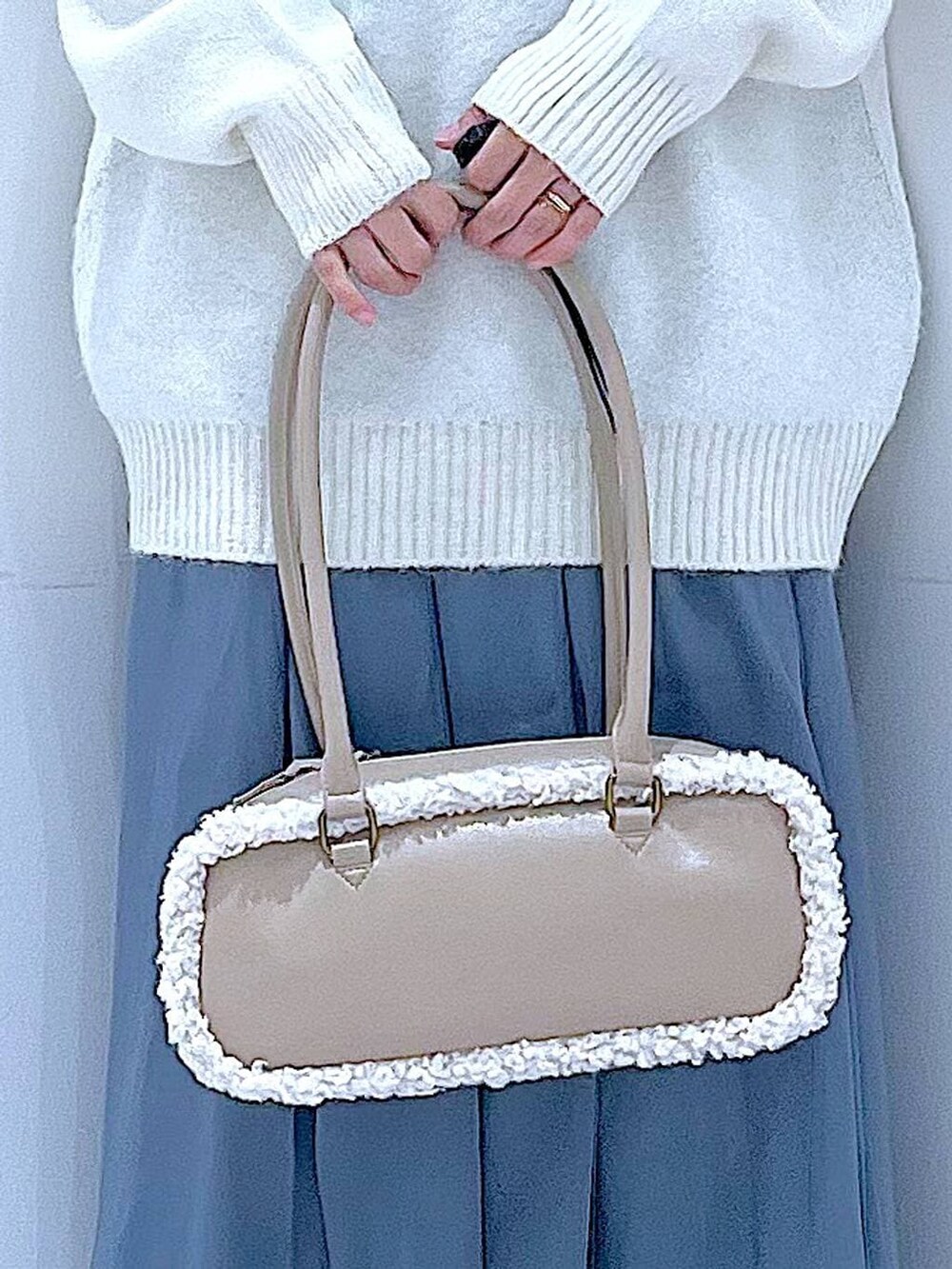 ブラック系のブーツ、ブルー系のスカート、ベージュ系のボストンバッグを着用したレディースの冬コーディネートの9枚目の写真