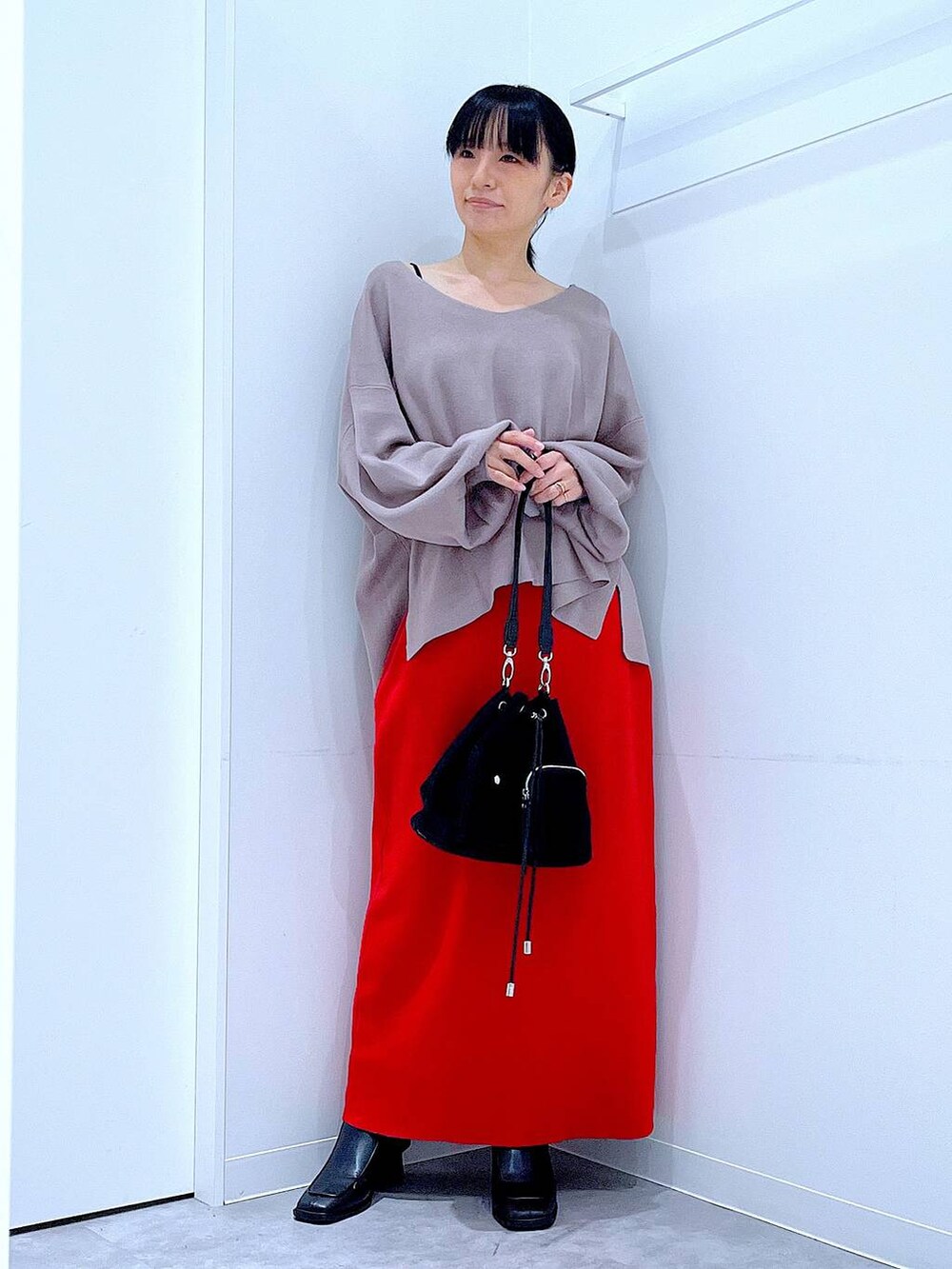 ブラウン系のニット/セーター、ブラック系のショルダーバッグ、ブラック系のブーツを着用したレディースの冬コーディネートの2枚目の写真