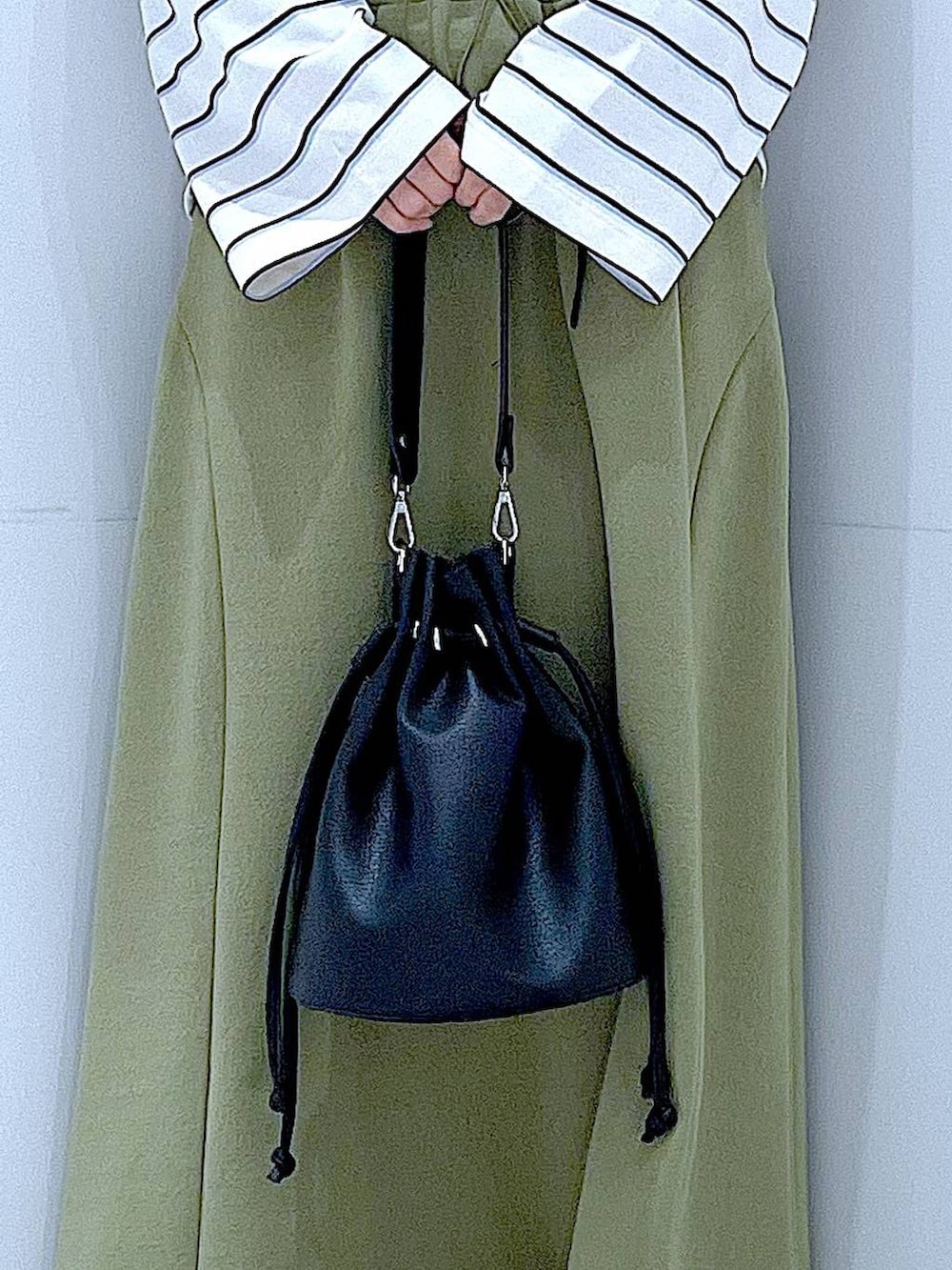 ブラック系のショルダーバッグ、グリーン系のスカート、ホワイト系のTシャツ/カットソーを着用したレディースの冬コーディネートの9枚目の写真