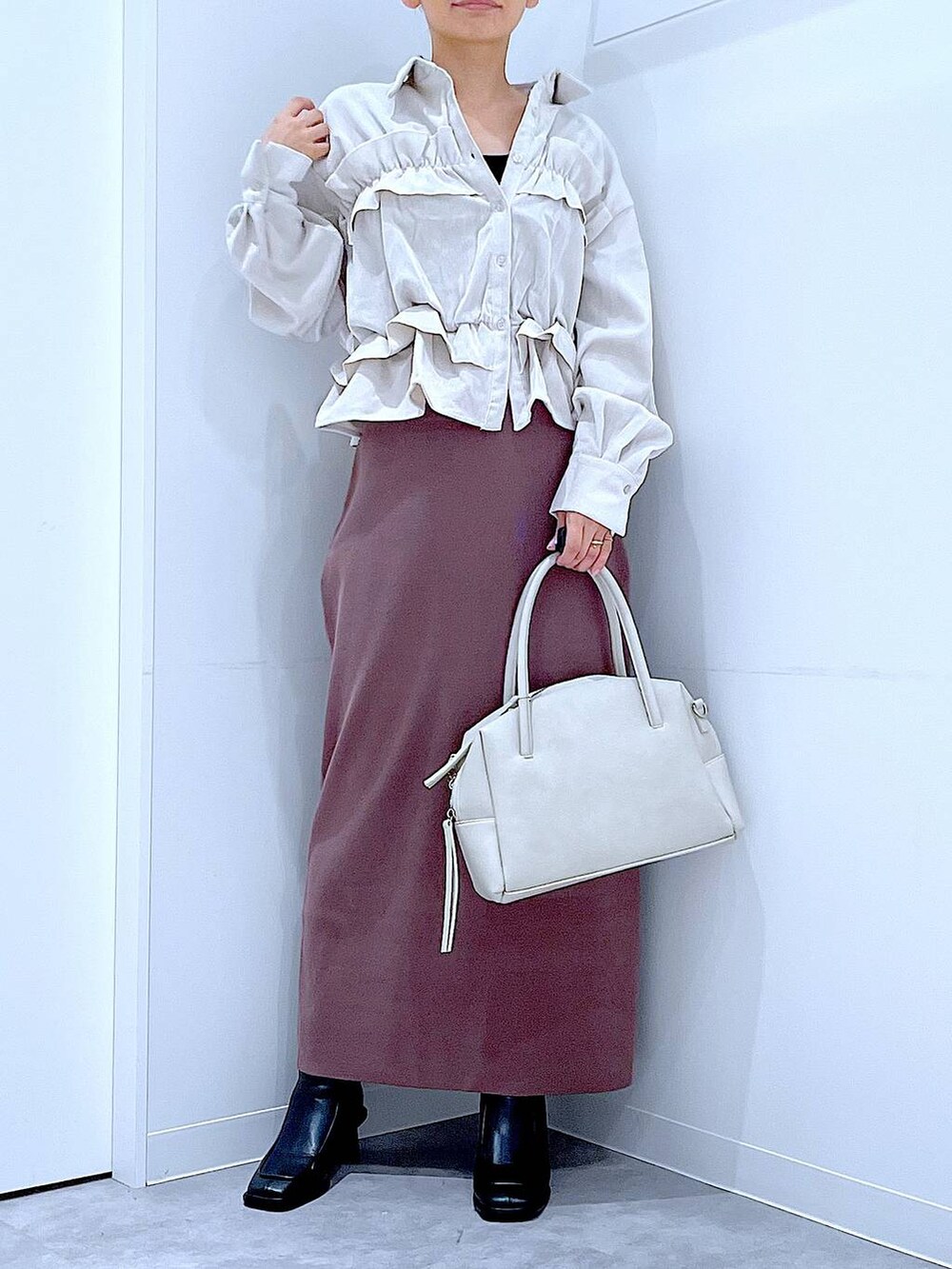 グレー系のボストンバッグ、ブラック系のブーツ、ベージュ系のシャツ/ブラウスを着用したレディースの秋コーディネートの6枚目の写真