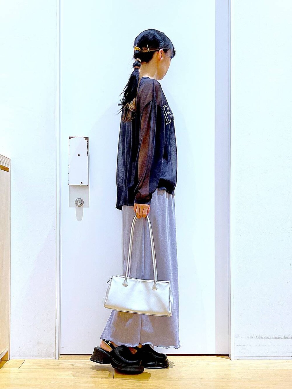 パープル系のスカート、ブラック系のサンダル、グレー系のニット/セーターを着用したレディースの春コーディネートの4枚目の写真