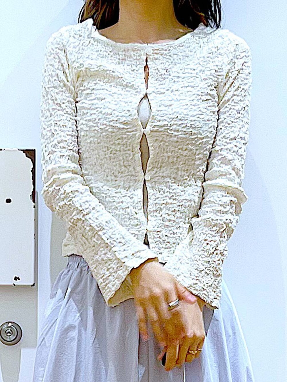 ホワイト系のカーディガン/ボレロ、イエロー系のニット/セーター、ホワイト系のパンプスを着用したレディースの春コーディネートの7枚目の写真