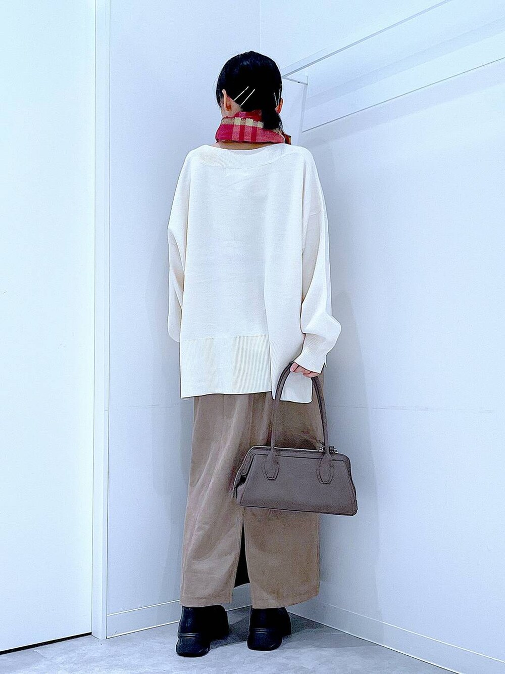 ブラック系のブーツ、ベージュ系のニット/セーター、ブラウン系のスカートを着用したレディースの秋コーディネートの5枚目の写真