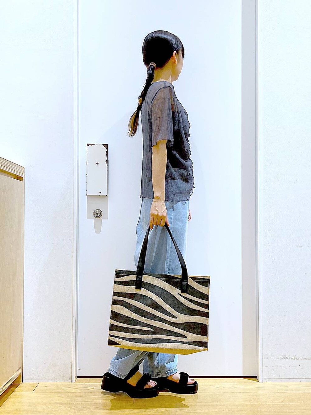 ブルー系のデニムパンツ、その他のトートバッグ、ブラック系のサンダルを着用したレディースの夏コーディネートの4枚目の写真