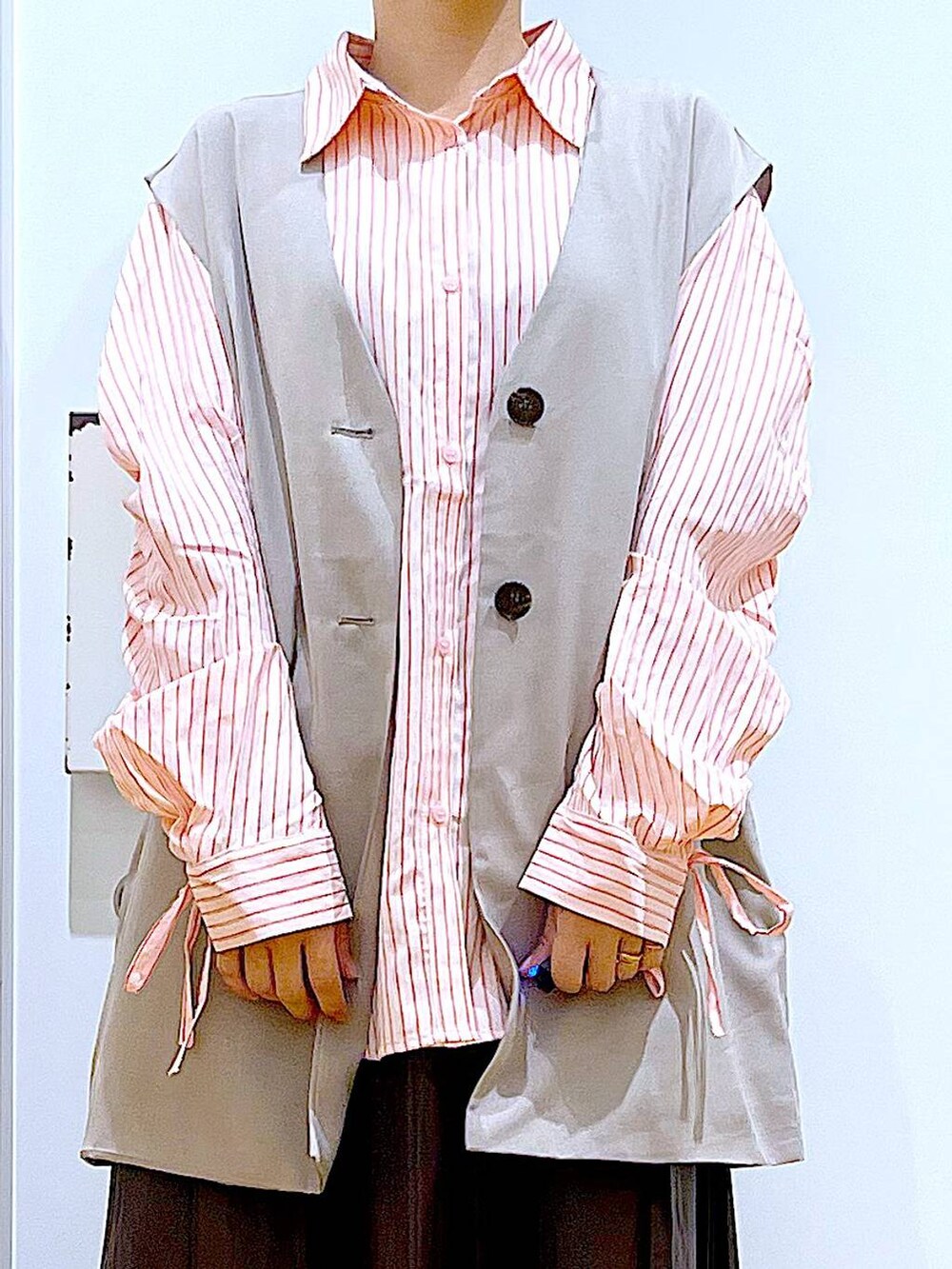 ベージュ系のショルダーバッグ、シルバー系のローファー、ベージュ系のベストを着用したレディースの秋コーディネートの7枚目の写真