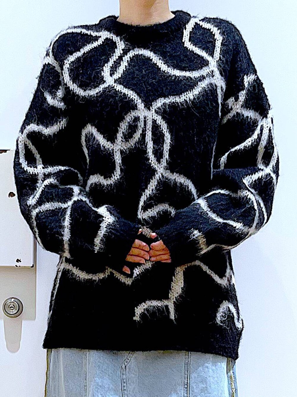 ブルー系のデニムスカート、ブラック系のブーツ、ブラック系のショルダーバッグを着用したレディースの冬コーディネートの7枚目の写真